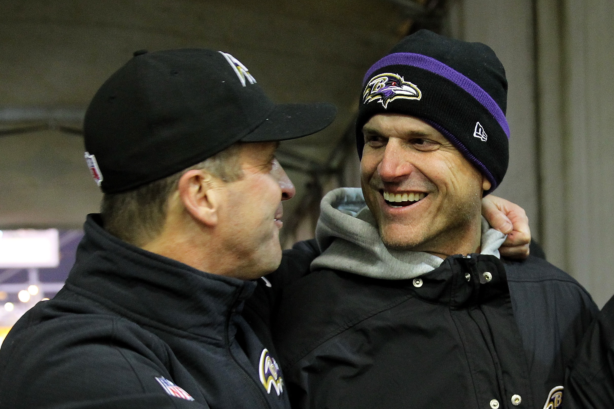 Michigan coach Jim Harbaugh (R) celebrates with his brother, head coach John Harbaugh (L) of the Baltimore Ravens after the Ravens defeated the Pittsburgh Steelers 30-17 in their AFC Wild Card game at Heinz Field on January 3, 2015, in Pittsburgh, Pennsylvania.