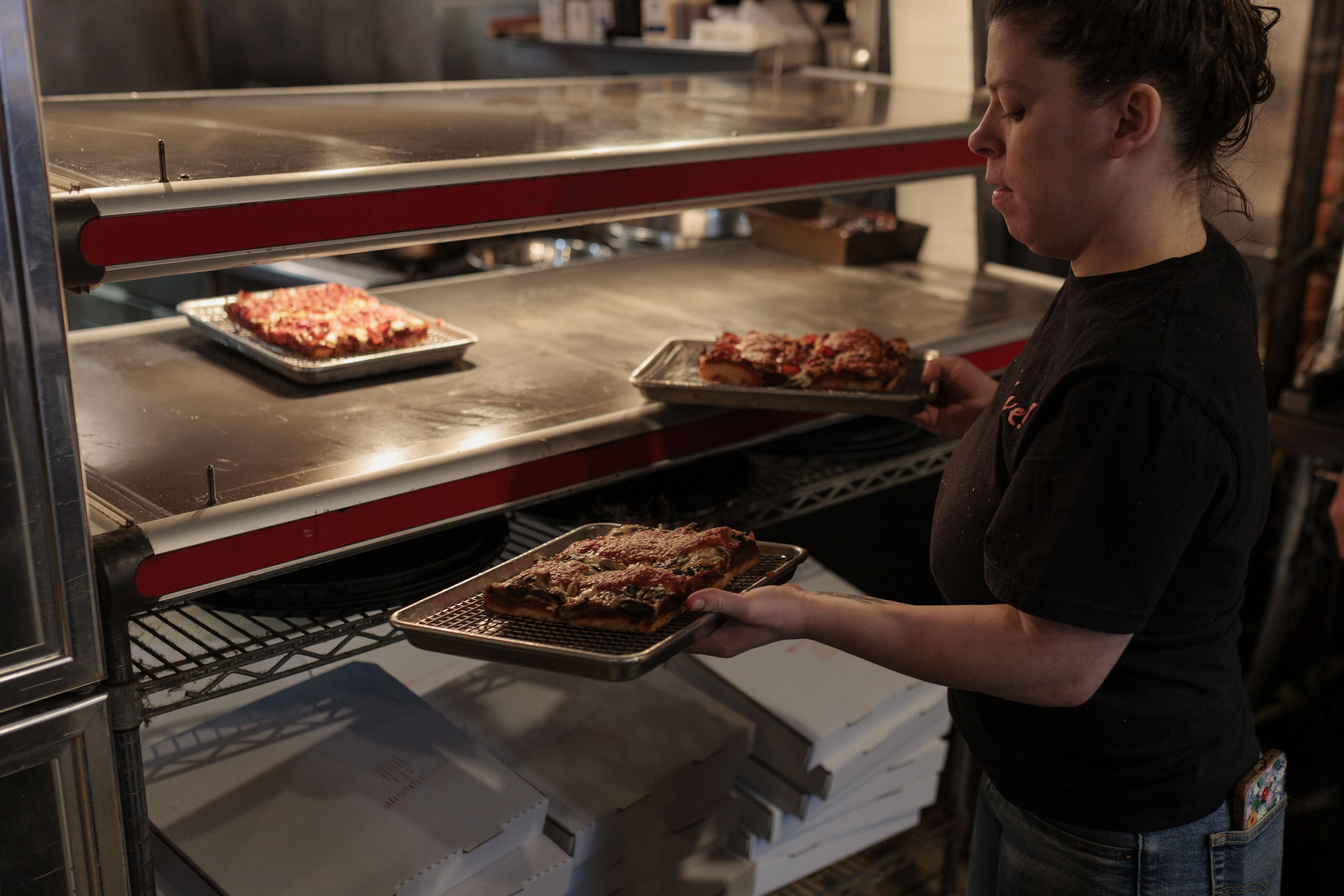 Adrianna Svehla, a server at Underground Pizza’s downtown Baltimore location, serves Detroit-style pizza during a lunch rush. 
