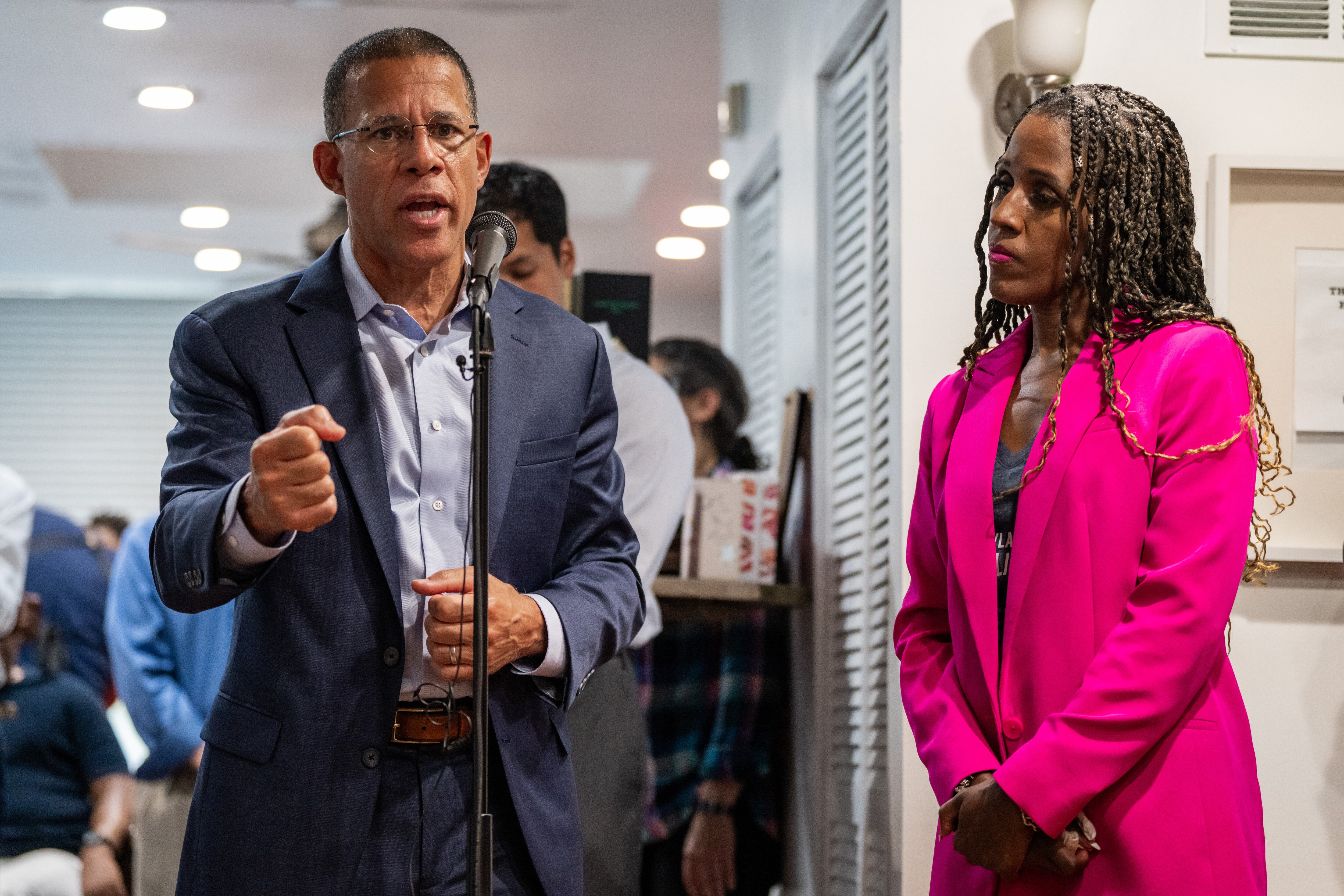 Anthony Brown, left, speaks at the mic and Natasha Dartigue listens.
