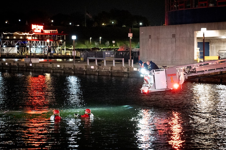 More than a dozen Baltimore fire trucks and police cars lined the area near the Pier 5 Pavilion on Tuesday, Nov. 18, 2025, as divers entered the water and rescue boats searched for the water.