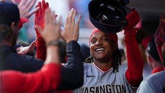 Washington Nationals shortstop CJ Abrams high fives teammates after scoring a run in the top of the first inning against the Philadelphia Phillies.