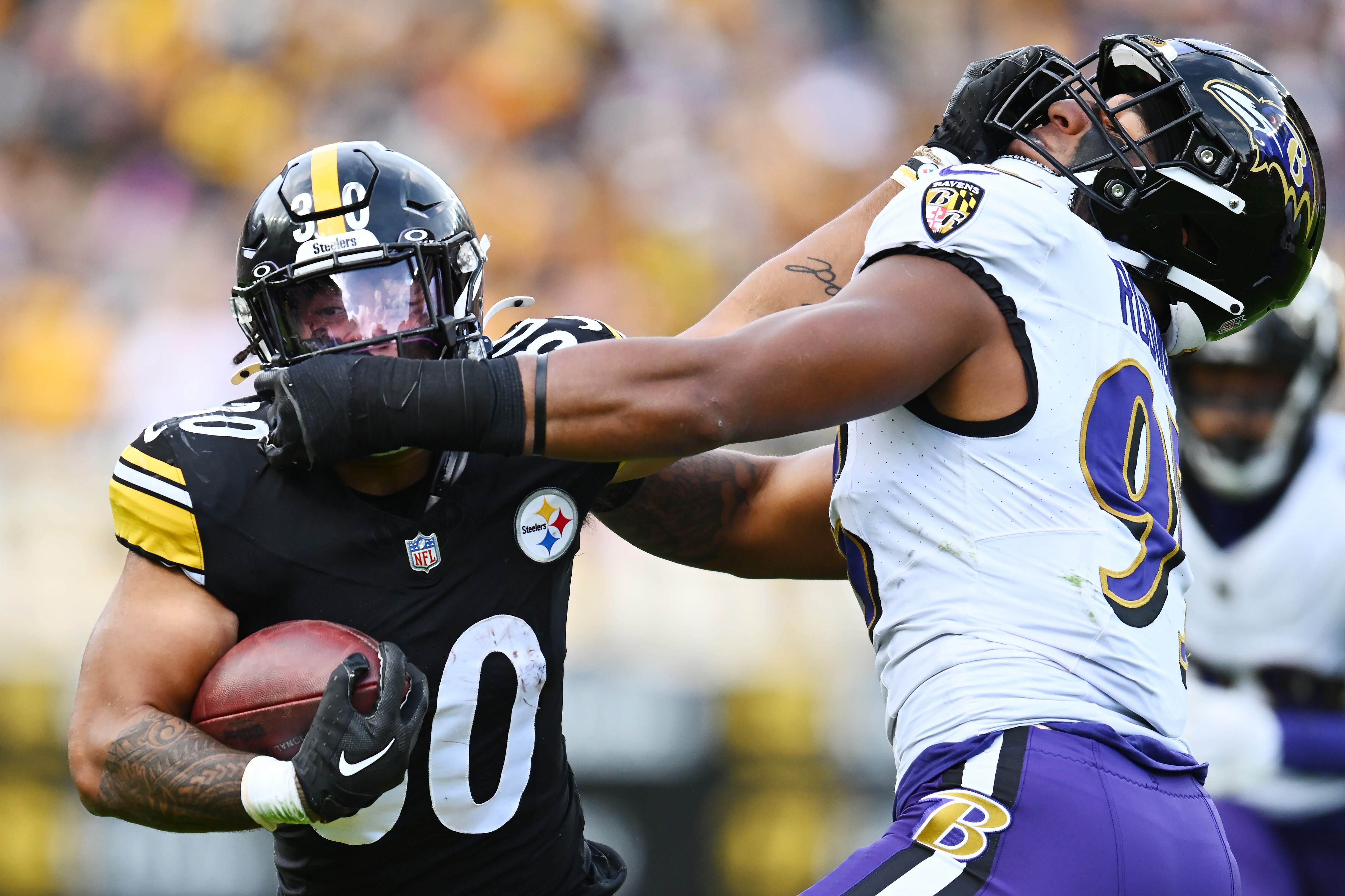 Jaylen Warren of the Steelers stiff-arms Tavius Robinson of the Ravens during the fourth quarter Sunday in Pittsburgh.