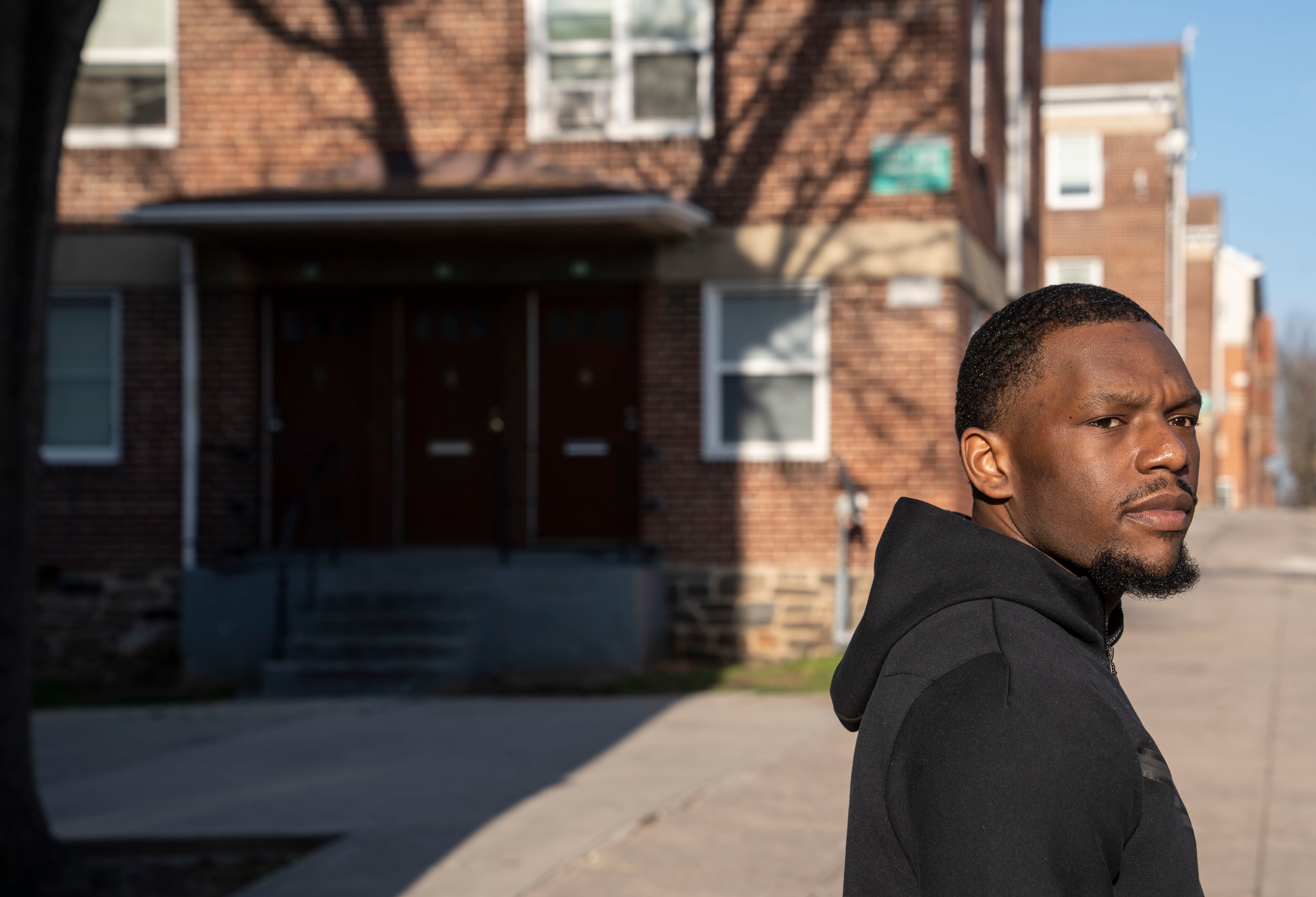 Lamar Richards, a current resident of DC, poses for portraits near his childhood home in Baltimore, Wednesday, March 29, 2023.