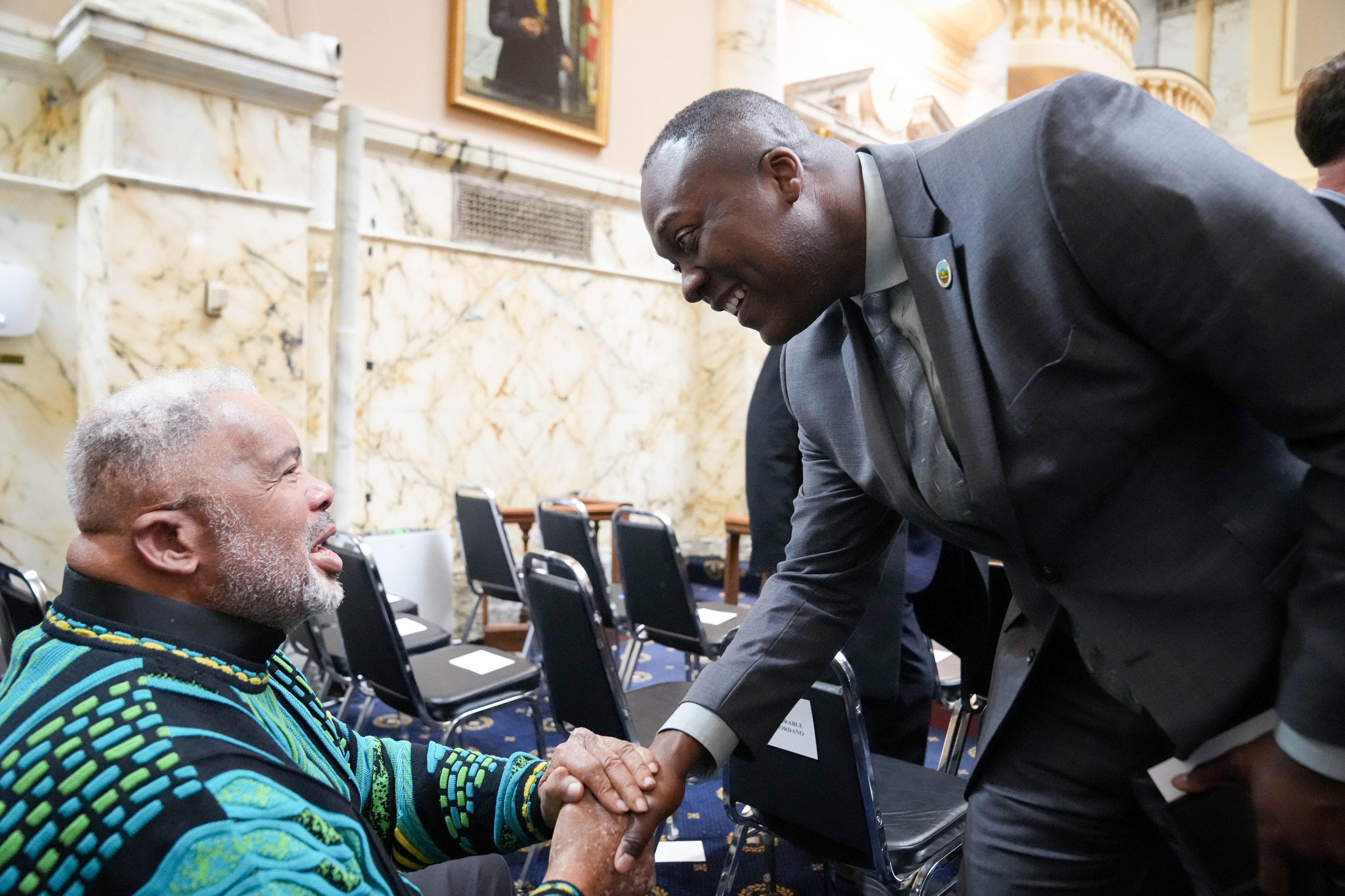 Howard County Executive Calvin Ball, right, shakes hands with former Sen. Larry Young at the Maryland State House in Annapolis on Wednesday.