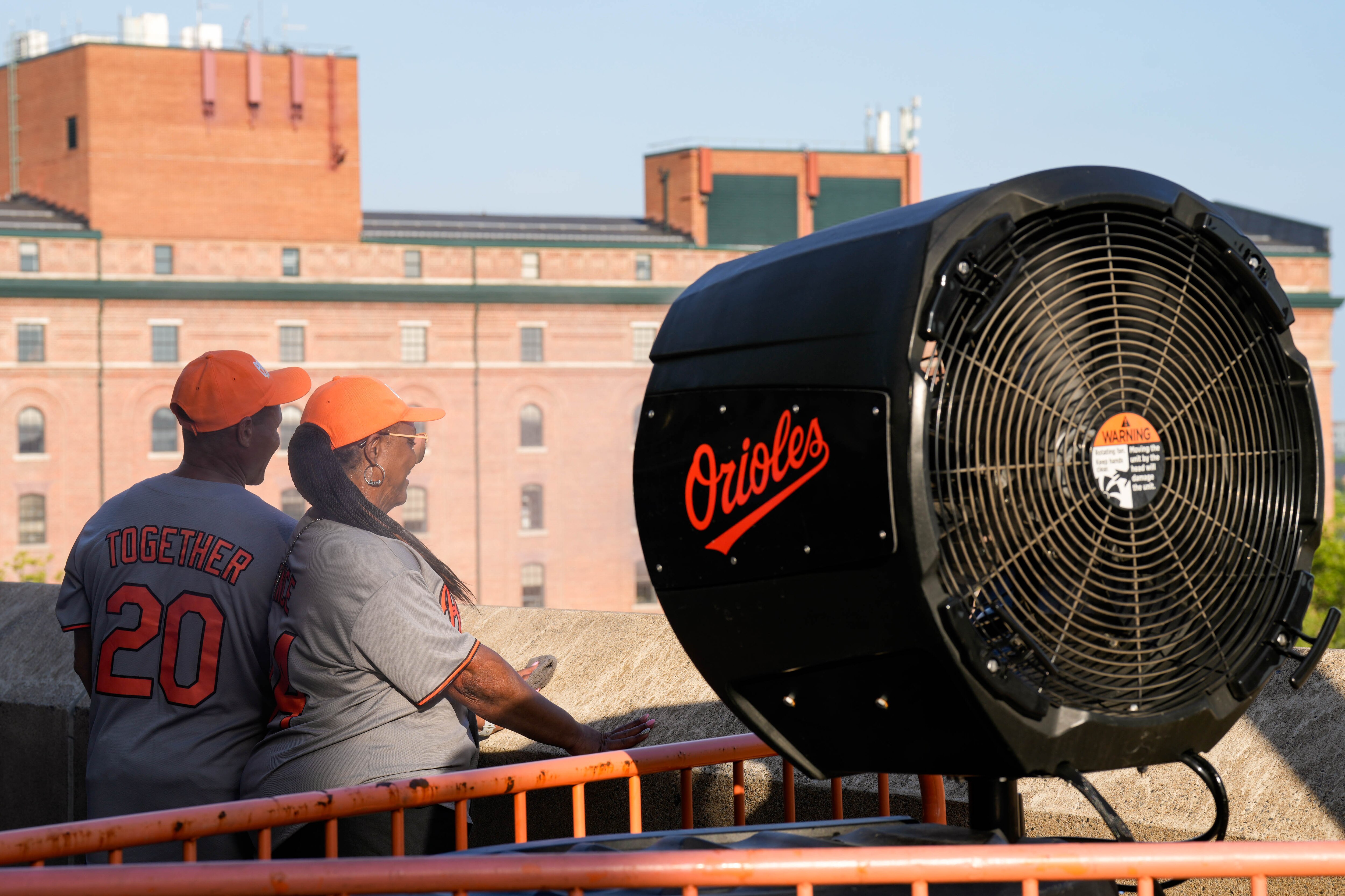 Baltimore Orioles fans Terry and Devonia Alston celebrate an anniversary together by cooling off at a misting station during a game against the Texas Rangers at Orioles Park at Camden Yards in Baltimore, Md. on Monday, June 23, 2025.