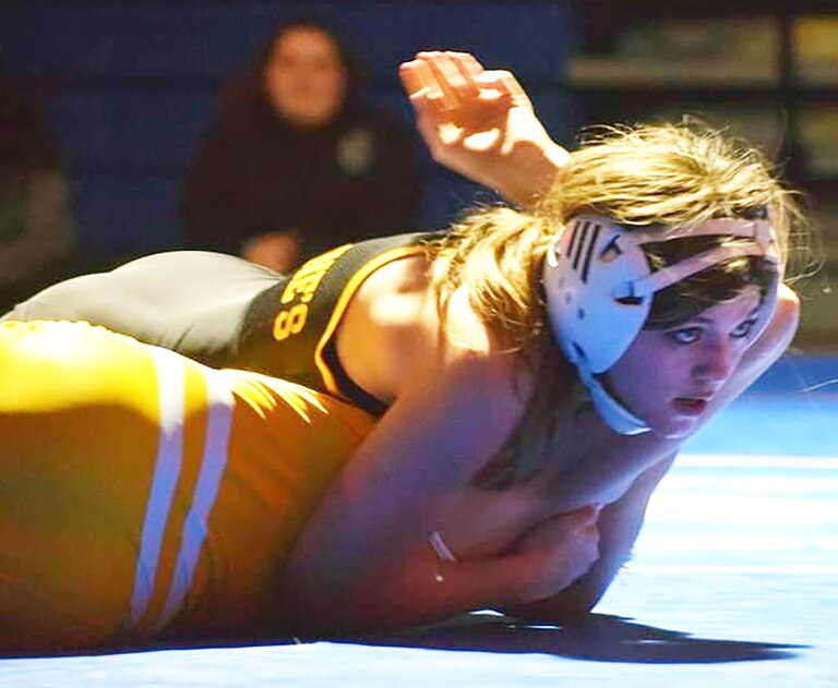 "It's a lot of pressure returning as a state champion," said 100-pound sophomore Ally Conley, the Lions' first-ever female titlist. "It's amazing and humbling to be a pioneer." Above, she pins a male opponent from Southern-AA High School.