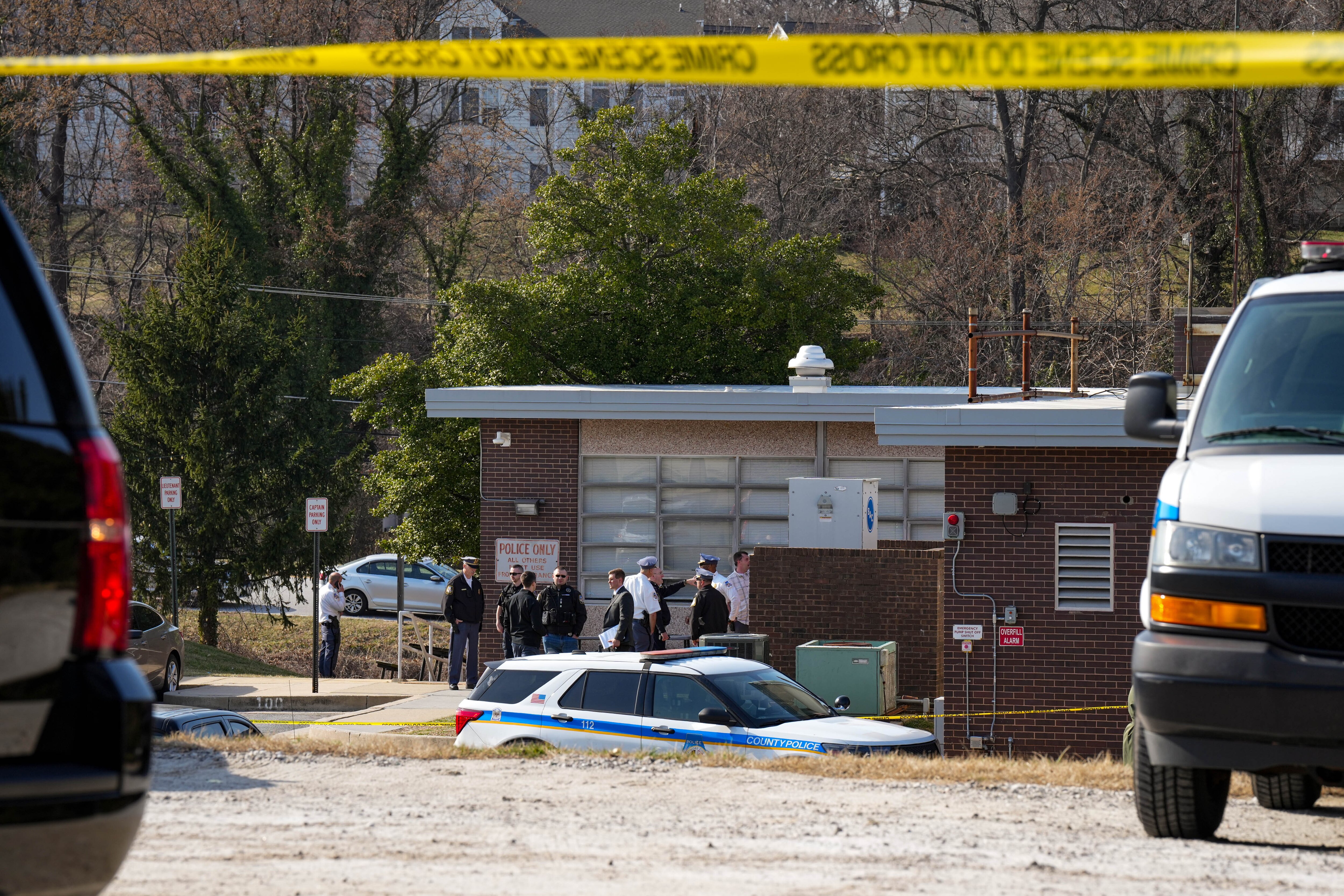 Police officers speak among themselves outside the southwest Baltimore County police precinct adjacent to the UMBC campus following a shooting at the Wilkens Police Precinct in Catonsville, Md. on Thursday, March 13, 2025.