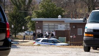 Police officers speak among themselves outside the southwest Baltimore County police precinct adjacent to the UMBC campus following a shooting at the Wilkens Police Precinct in Catonsville, Md. on Thursday, March 13, 2025.