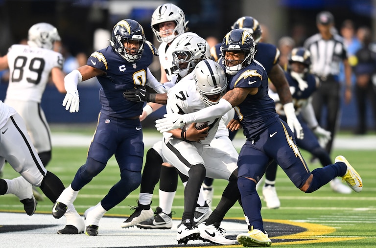 INGLEWOOD, CALIFORNIA - NOVEMBER 30: Daiyan Henley #0 of the Los Angeles Chargers sacks Geno Smith #7 of the Las Vegas Raiders in the first quarter of a game at SoFi Stadium on November 30, 2025 in Inglewood, California.