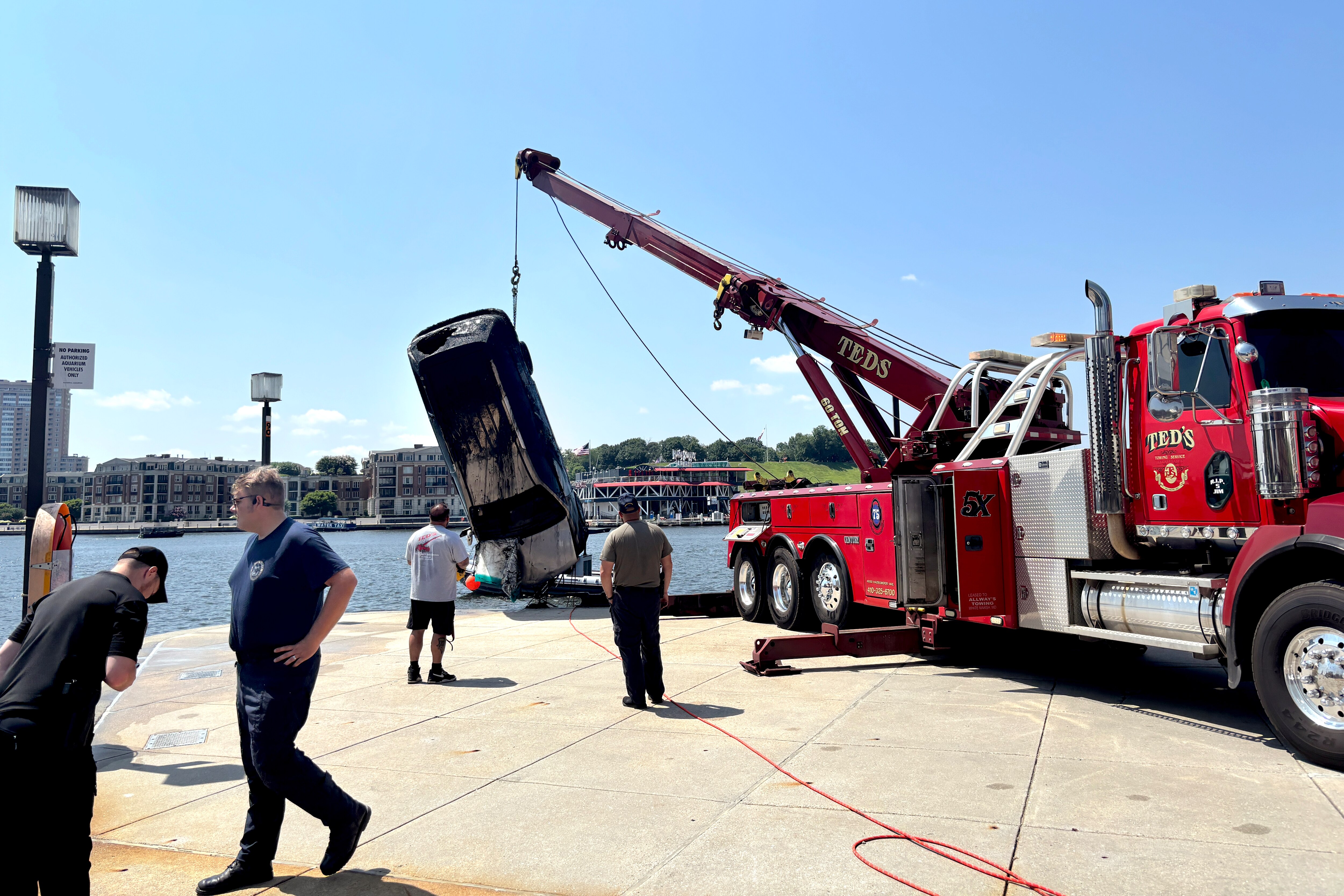 Baltimore City Fire and the Baltimore City Police Underwater Recovery Team work to pull a Silver Cab from the Inner Harbor on Thursday, July 24, 2025.