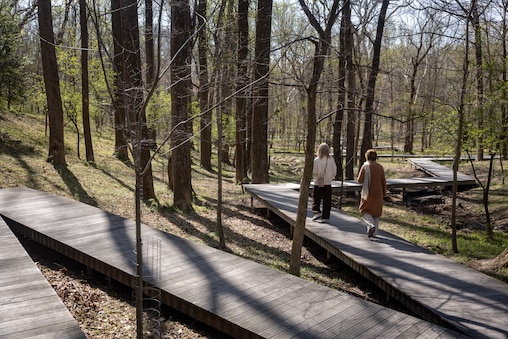THURSDAY, APRIL 9, 2026 - Visitors walk across a boardwalk on the grounds at the Glenstone Museum.