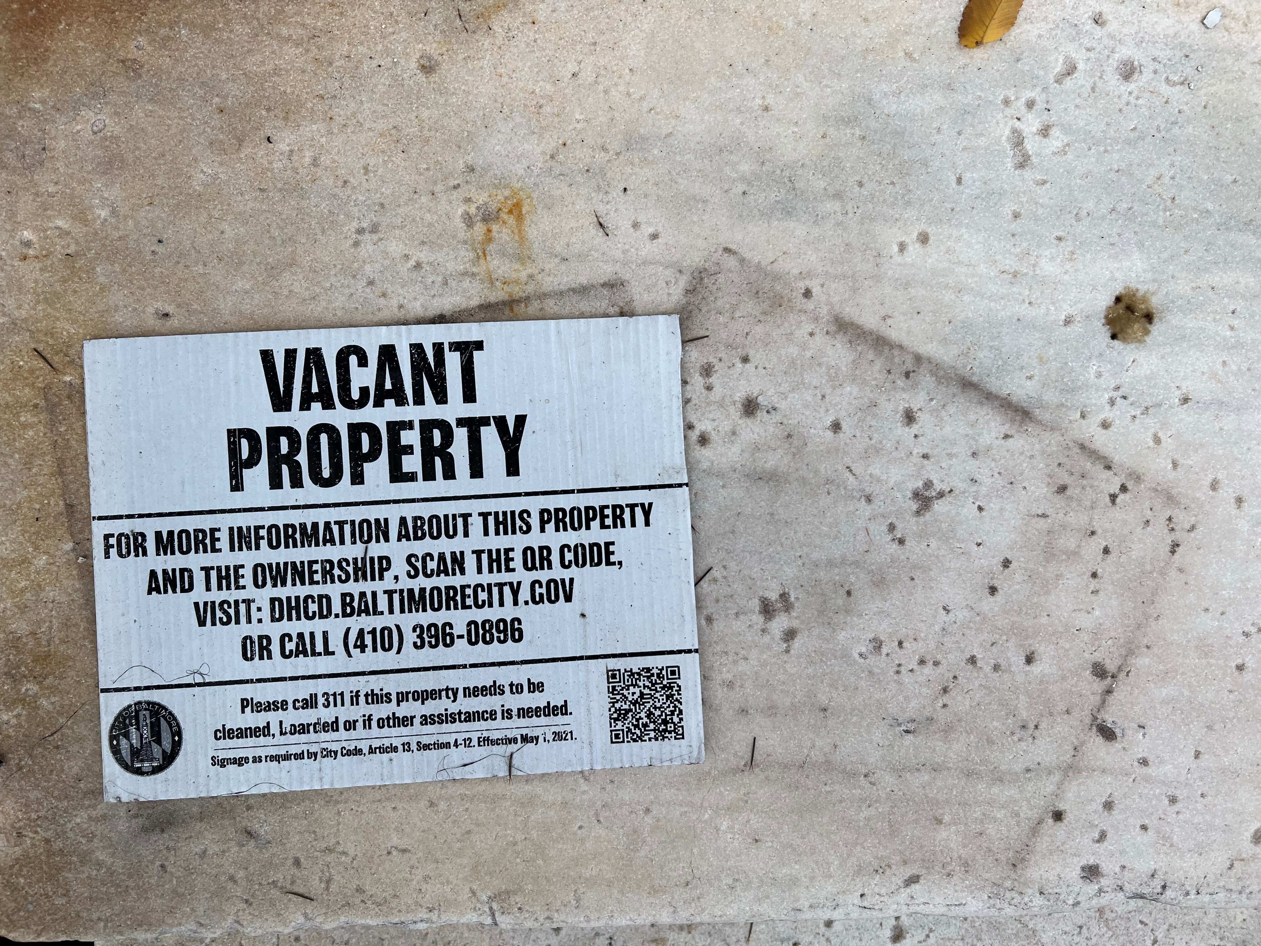 A vacant property notice sits on the marble steps of a West Baltimore home located in the Penn-North neighborhood and owned by an ABC Capital investor.