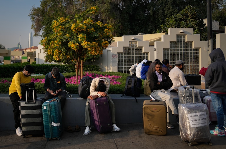 Passengers stranded by the closure of Dubai International Airport await for assistance in the airport parking lot in Dubai, United Arab Emirates, Sunday, March 1, 2026.
