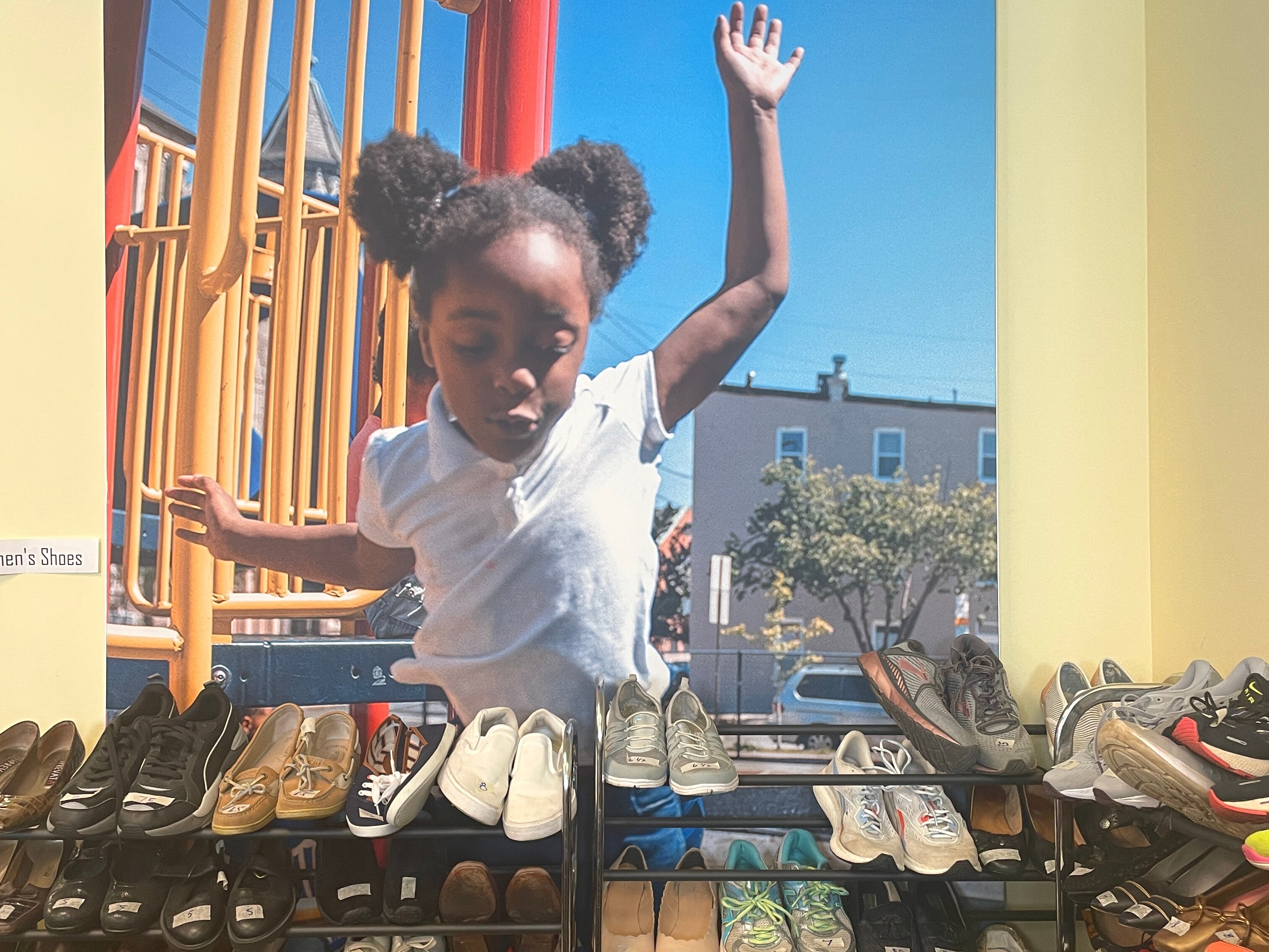 A row of shoes is arranged neatly in a corner for guests of Paul's Place to choose from.