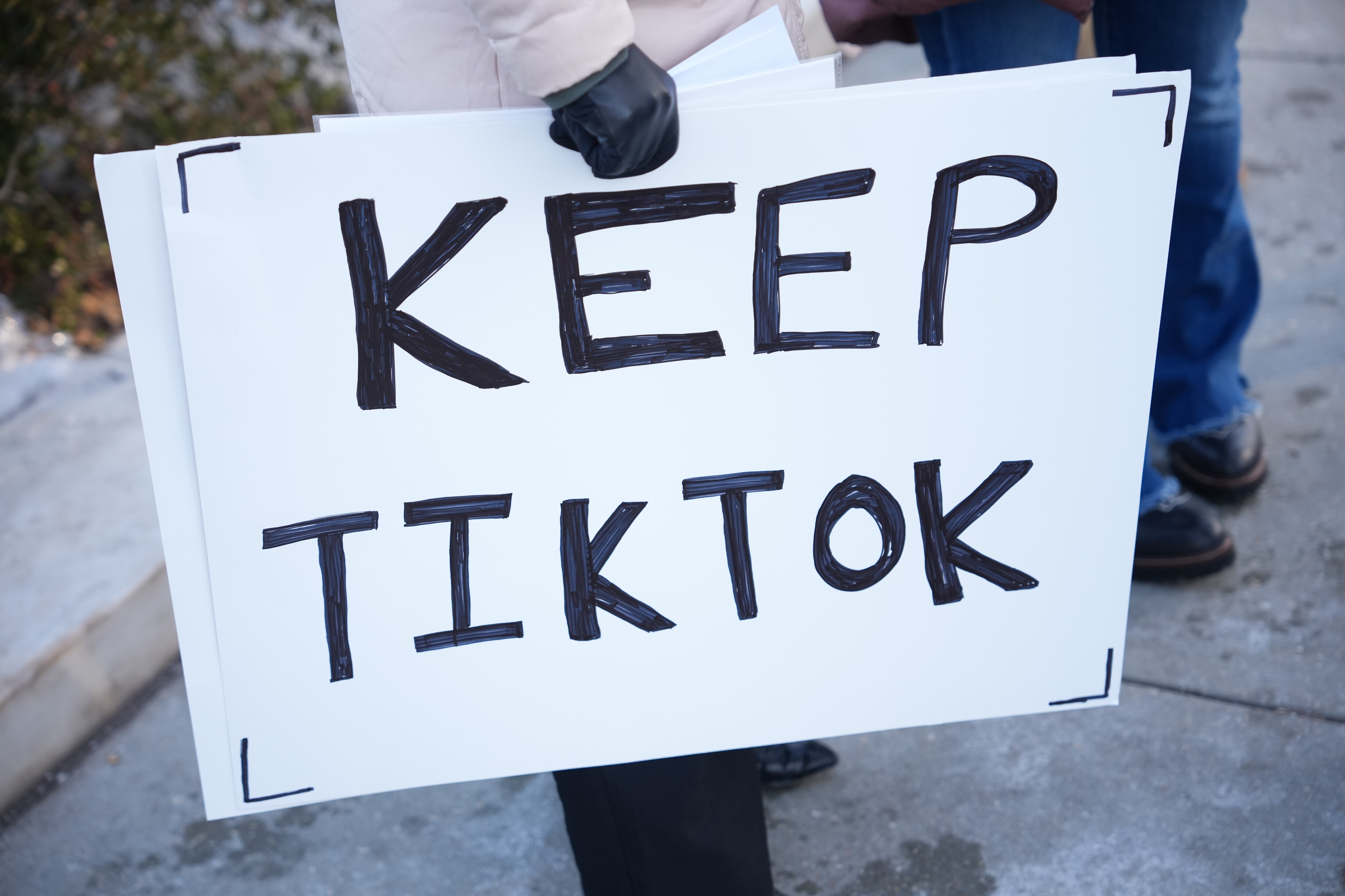 WASHINGTON, DC - JANUARY 10: Sarah Baus of Charleston, S.C., a content creator on TikTok, holds a sign that reads "Keep TikTok" outside the U.S. Supreme Court Building as the court hears oral arguments on whether to overturn or delay a law that could lead to a ban of TikTok in the U.S., on January 10, 2025 in Washington, DC. The future of the popular social media platform is at stake as the Supreme Court hears arguments on a law set to take effect the day before Inauguration Day that would force their China-based parent company to cut ties with TikTok due to national security concerns. (Photo by Andrew Harnik/Getty Images)