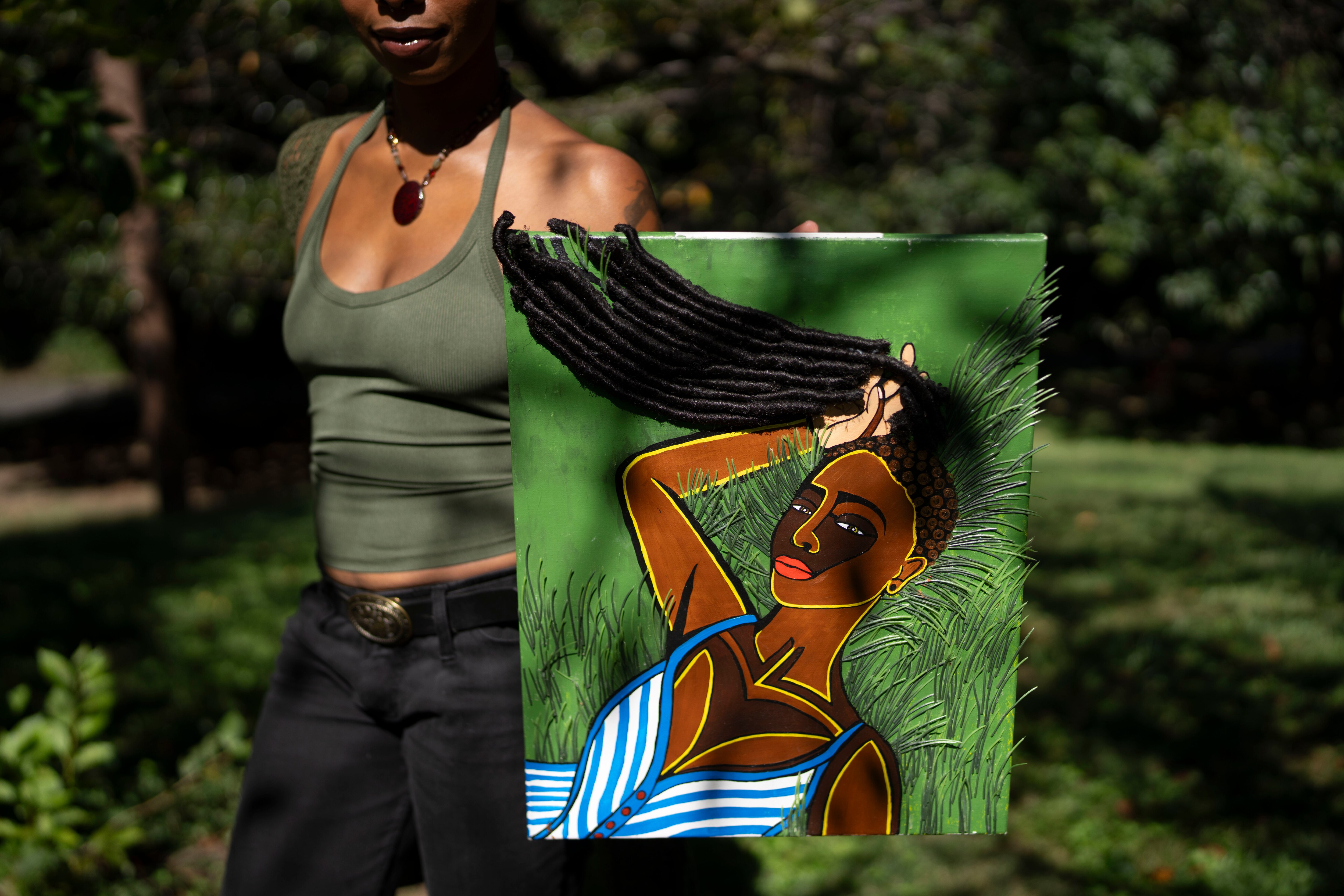 Zoe Inderia Austrie holds up artwork she has made in Wyman Park in Baltimore, Tuesday, September 15, 2026.