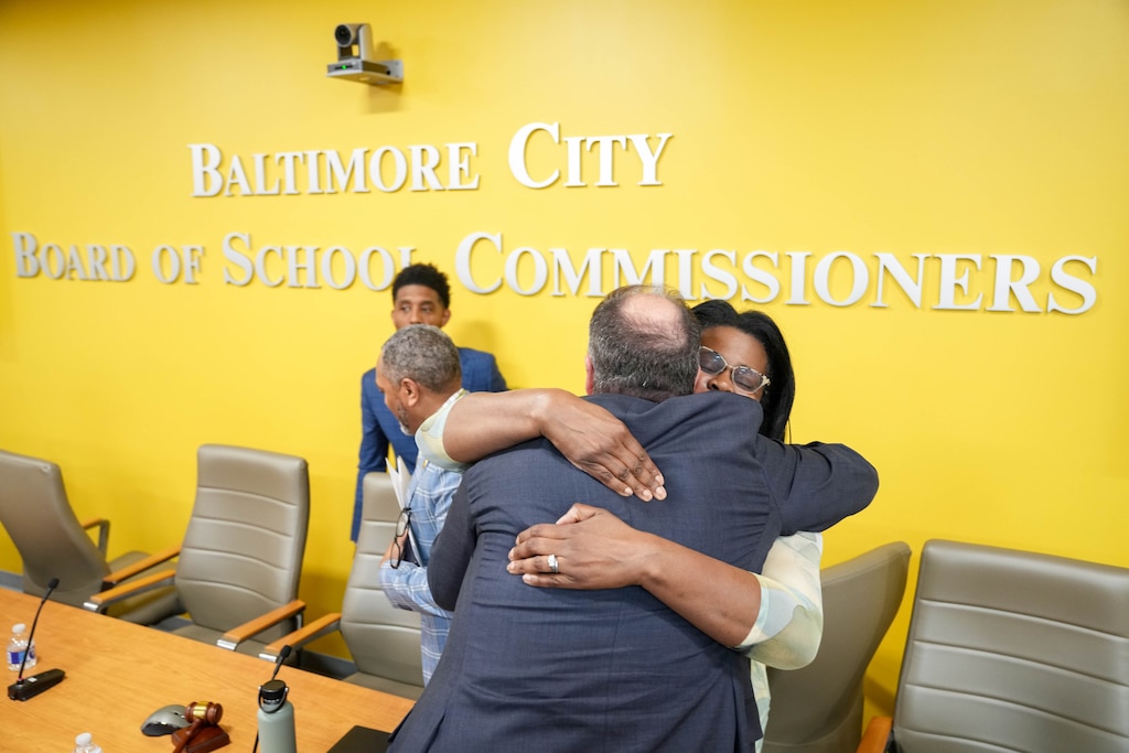 Outgoing city schools CEO Dr. Sonja Santelises, right, is embraced by an attendee following a Baltimore City Board of School Commissioners meeting at the Baltimore City Public Schools headquarters in Baltimore, Md. on Monday, April 20, 2026.
