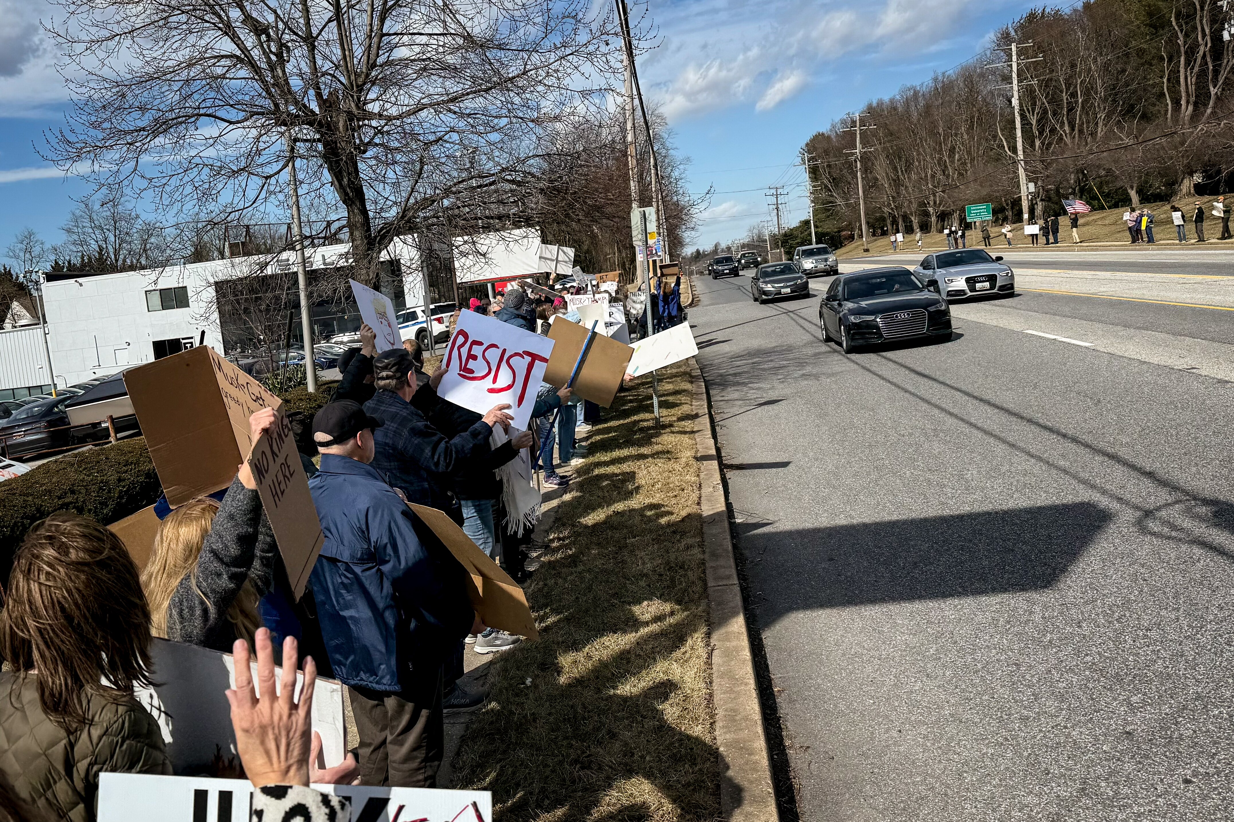 Protesters gather along the 9400 block of Reisterstown Rd, near the Tesla dealership in Owings Mills, to protest Elon Musk on Saturday, March 1, 2025.