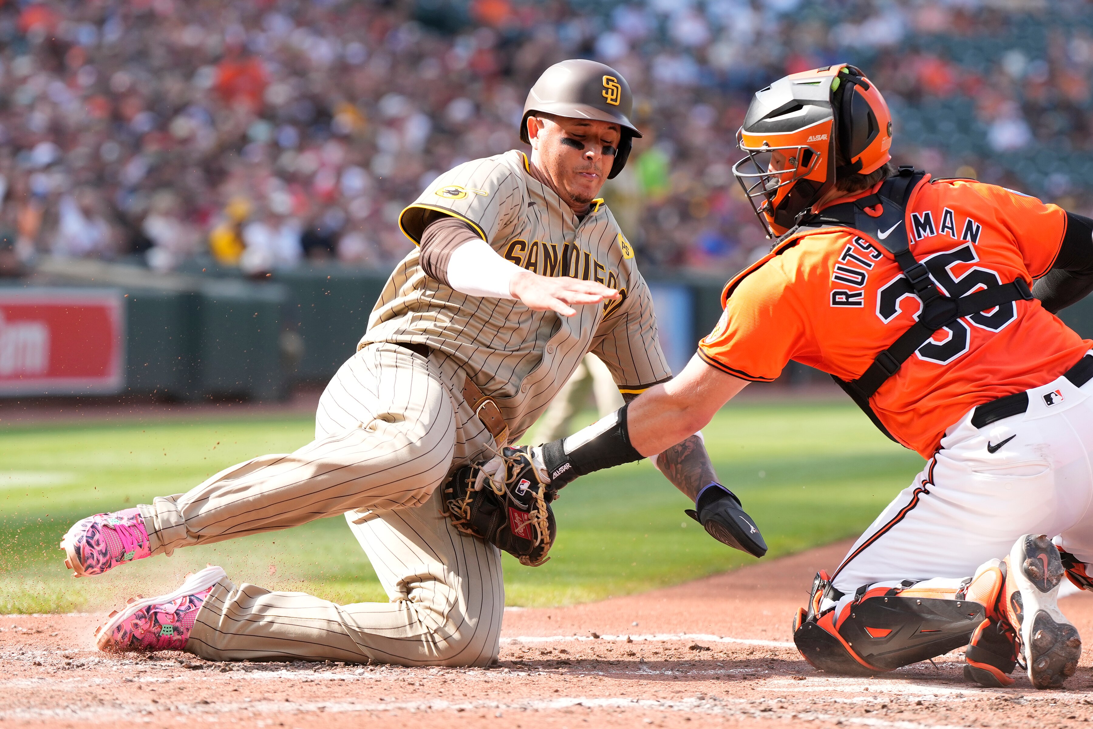 BALTIMORE, MD - JULY 27:  Adley Rutschman #35 of the Baltimore Orioles tags out Kyle Higashioka #20 of the San Diego Padres as he tries to score on a Jackson Merrill #3 fielder's choice in the third inning during a baseball game at Oriole Park at Camden Yards on July 27, 2024 in Baltimore, Maryland.  (Photo by Mitchell Layton/Getty Images)