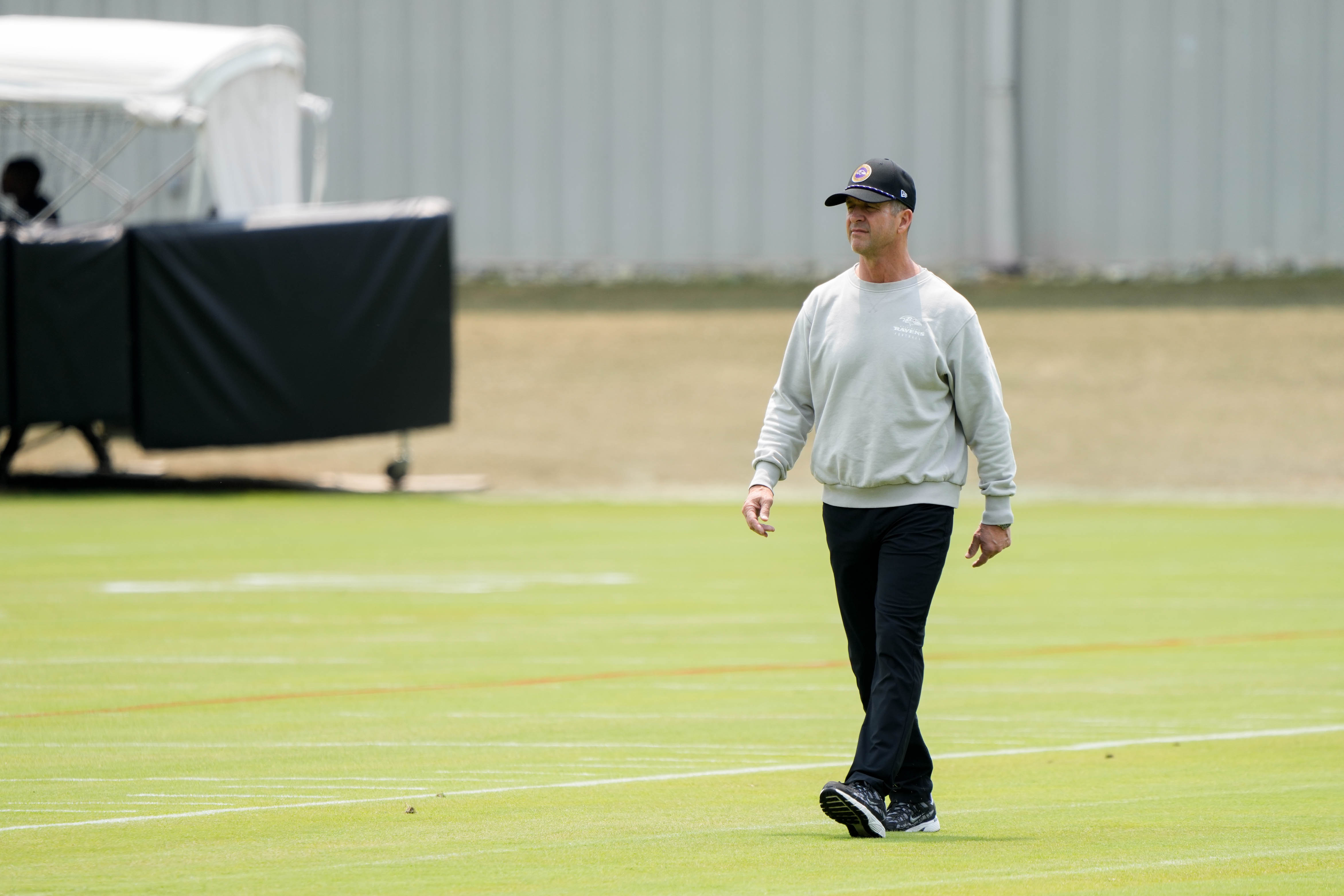 Coach John Harbaugh walks onto the practice field during the team’s organized team activities this month.