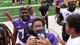 Baltimore Ravens guard John Simpson poses for a selfie with a fan during the team's NFL football training camp at the University of Maryland in College Park, Md., Saturday, Aug. 1, 2026. (AP Photo/Stephanie Scarbrough)