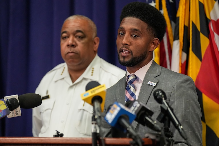 Baltimore Police Commissioner Michael Harrison, left, listens as Baltimore Mayor Brandon Scott speaks at a press conference.