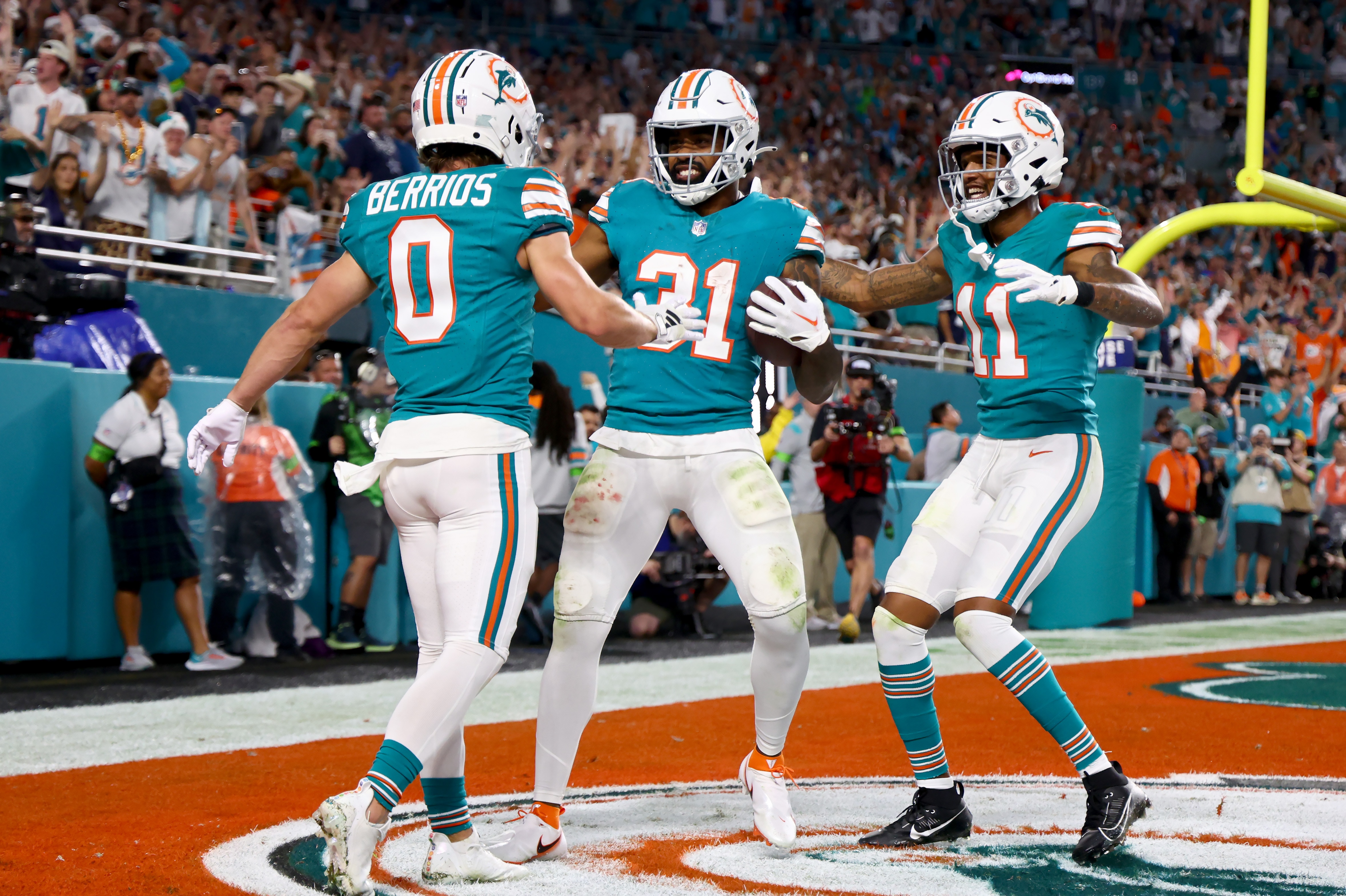 The Dolphins' Raheem Mostert (31) celebrates a touchdown with Braxton Berrios and Cedrick Wilson Jr. on Sunday during the second quarter against the Cowboys.