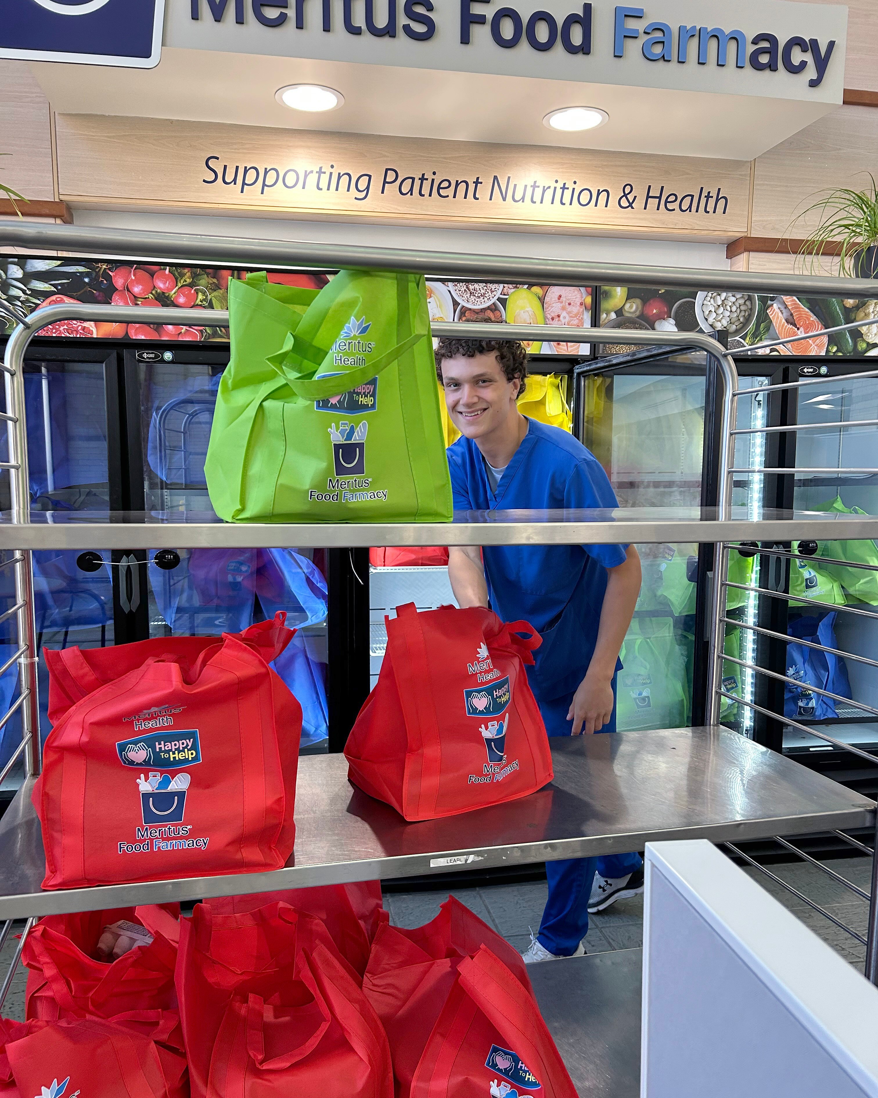A Meritus Nutrition Services worker unloads bags of food into refrigerators at the Meritus Food Farmacy in the Robinwood Professional Center in Hagerstown.