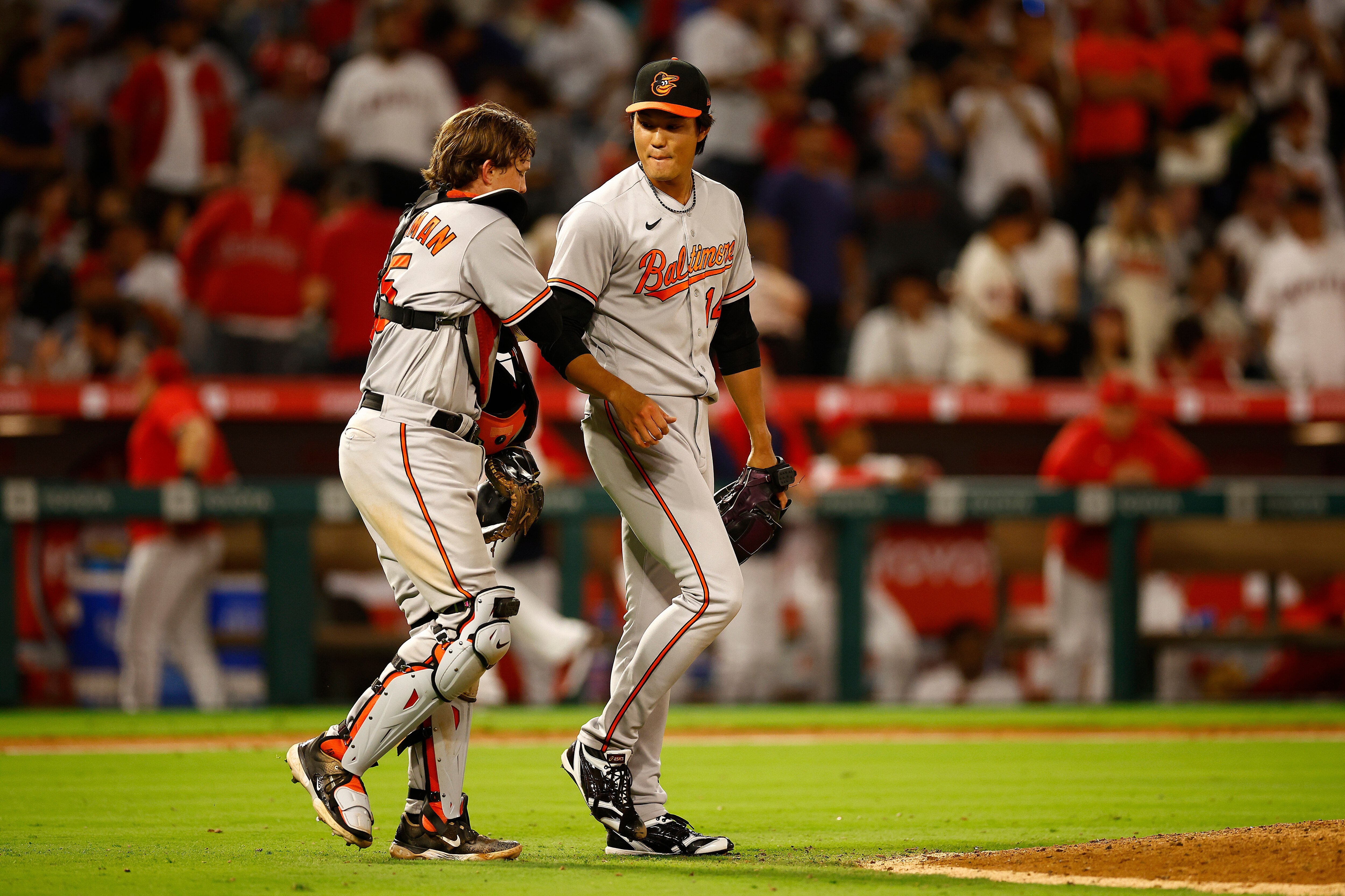 Shintaro Fujinami, No. 14, and Adley Rutschman, No. 35, of the Baltimore Orioles celebrate a win against the Los Angeles Angels at Angel Stadium of Anaheim on Sept. 5, 2023 in Anaheim, California.