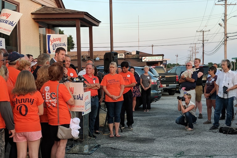July 14.2018 - Johnny Olszewski Jr. holding a press conference outside his Dundalk campaign headquarters after winning the Democratic nomination for Baltimore County executive following a tight race and a recount. You can see the sign for Costas in the background.
