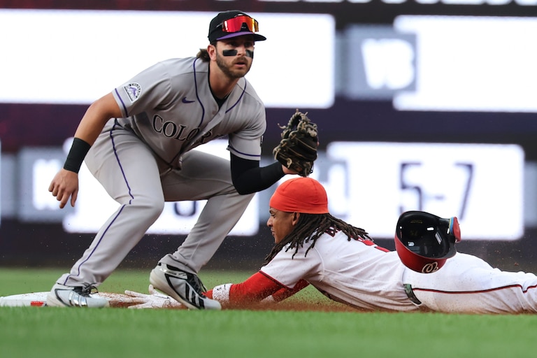 Washington Nationals' CJ Abrams, right, slides into second base for a steal during against the Colorado Rockies during the first inning.
