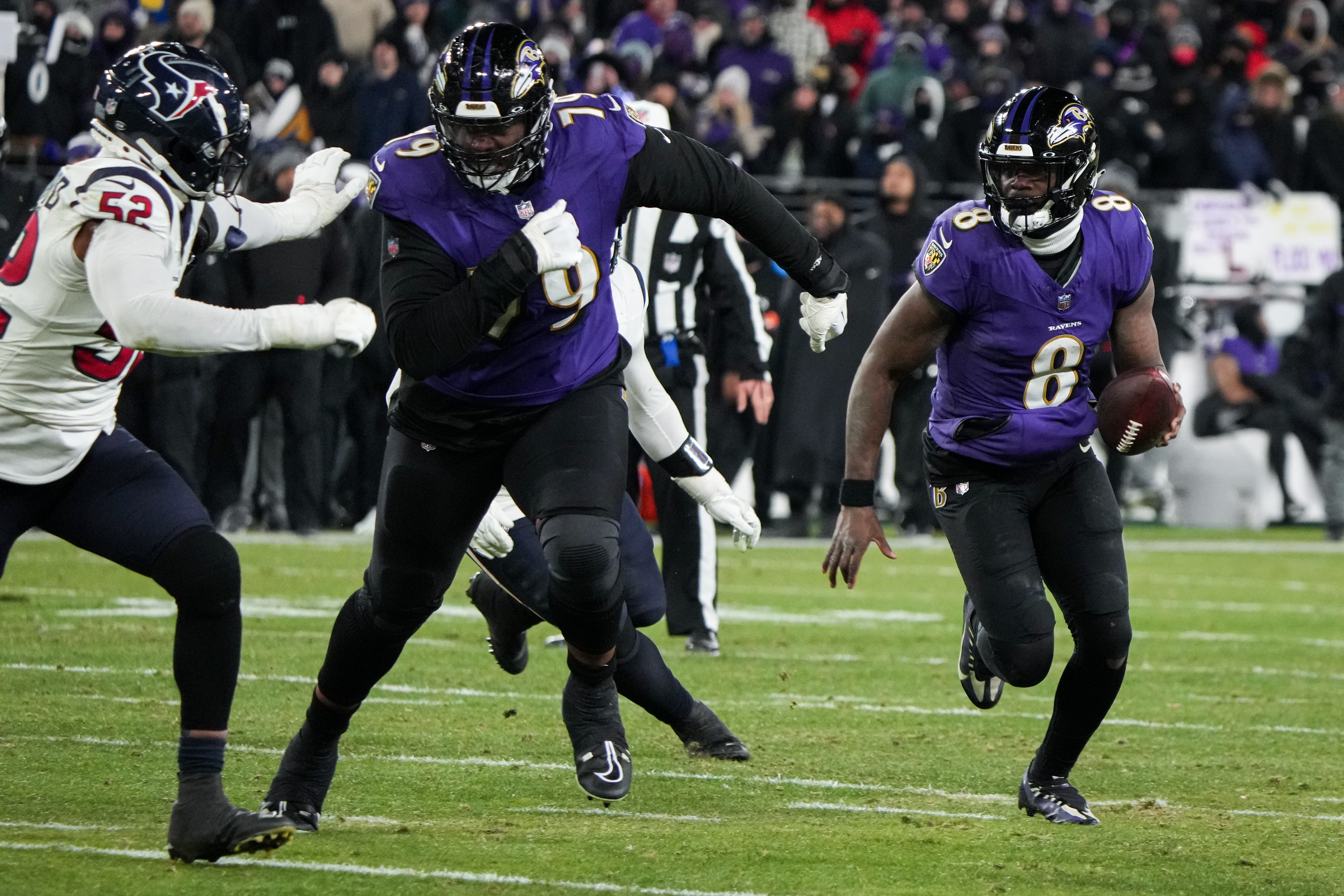 Baltimore Ravens offensive tackle Ronnie Stanley (79) blocks Houston Texans defensive end Jonathan Greenard (52) so quarterback Lamar Jackson (8) can score a touchdown during a playoff game at M&T Bank Stadium on January 20, 2024.