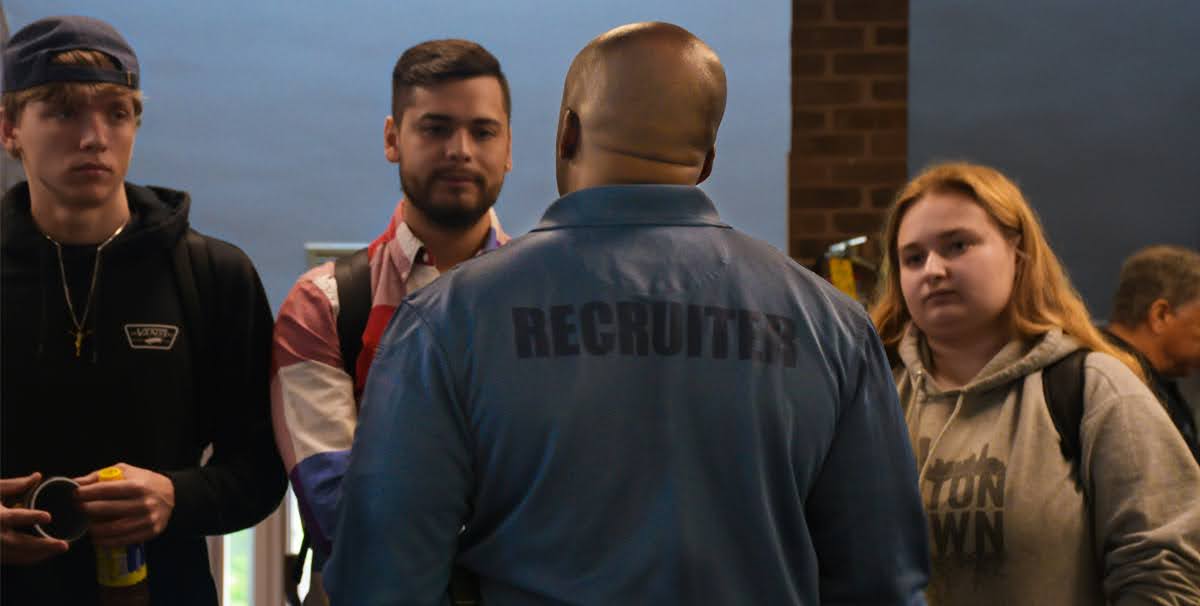 Robbie Wright, Baltimore County Police corporal, speaks with students attending a criminal justice fair at Community College of Baltimore County.