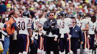 Mike Ditka, head coach for the Chicago Bears, looks on with arms folded from the sideline during the National Football Conference Central Division game against the Green Bay Packers on 16th September 1990 at Lambeau Field in Green Bay, Wisconsin, United States. The Chicago Bears won the game 31 - 13.