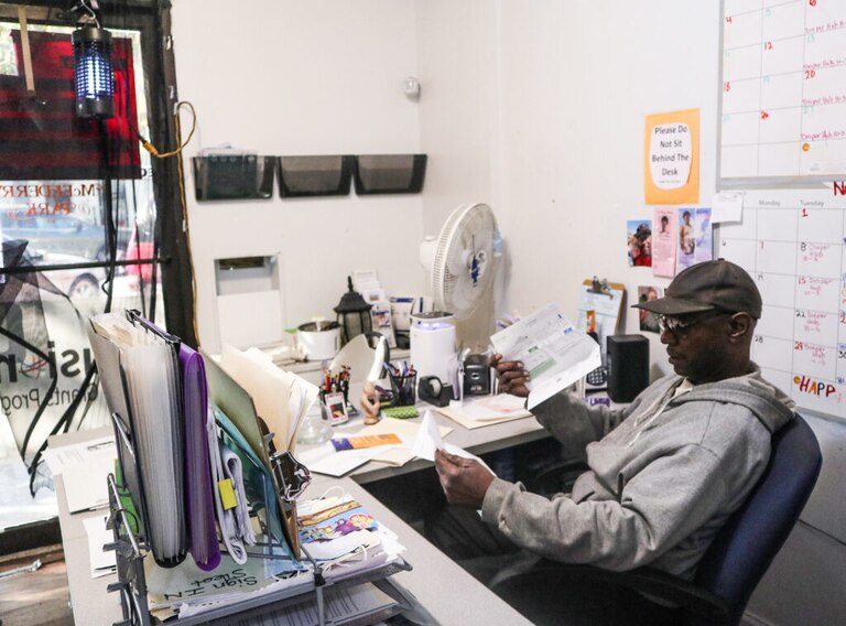 Smith sits at the front desk of the resource center and opens mail for the association.