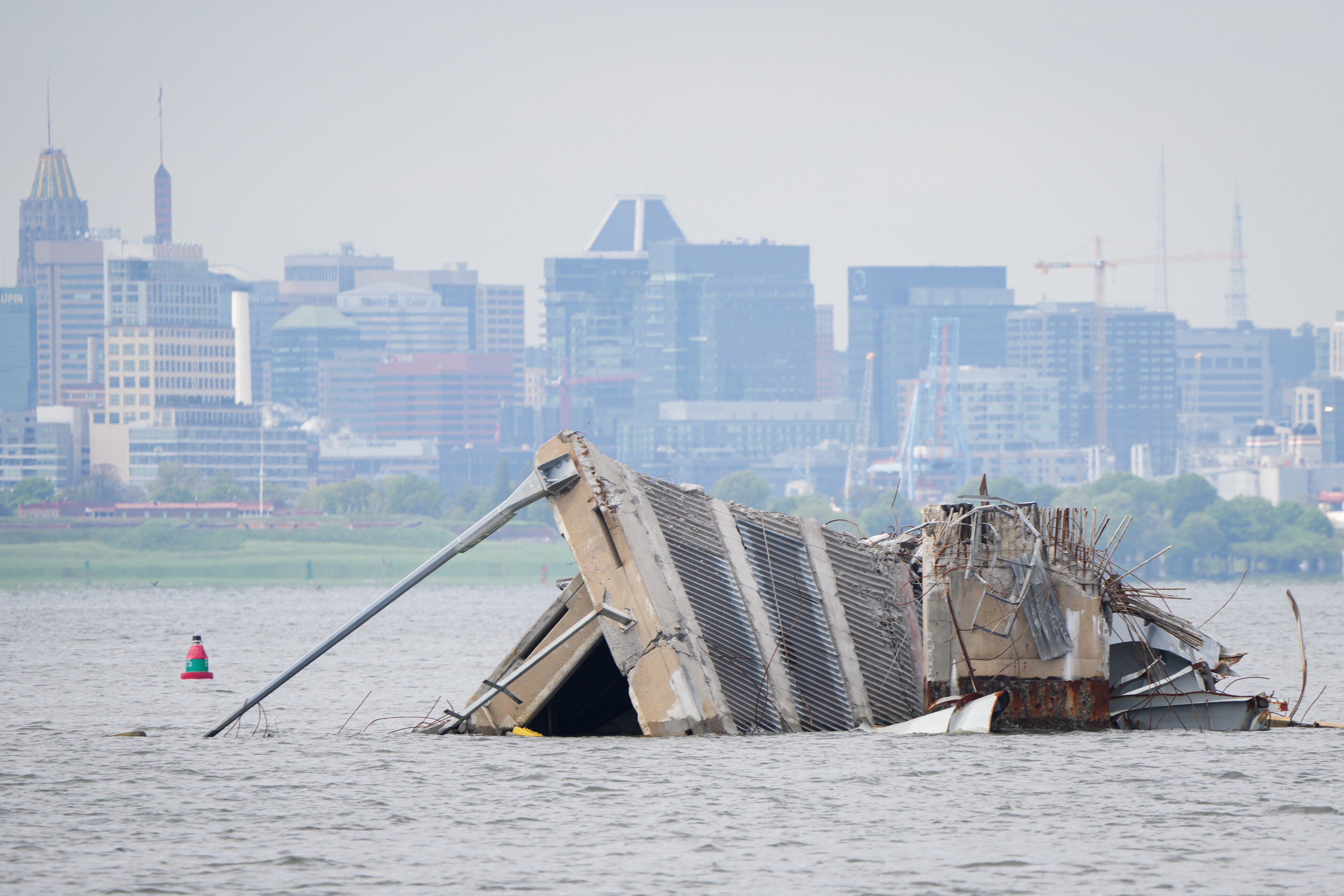 Wreckage from the collapsed Francis Scott Key Bridge is seen in front of the Baltimore skyline from a boat in the Patapsco River on April 25, 2024.