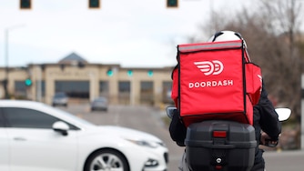 A food delivery motorcycle rider waits for the traffic light to change March 30, 2020, in Lone Tree, Colo.