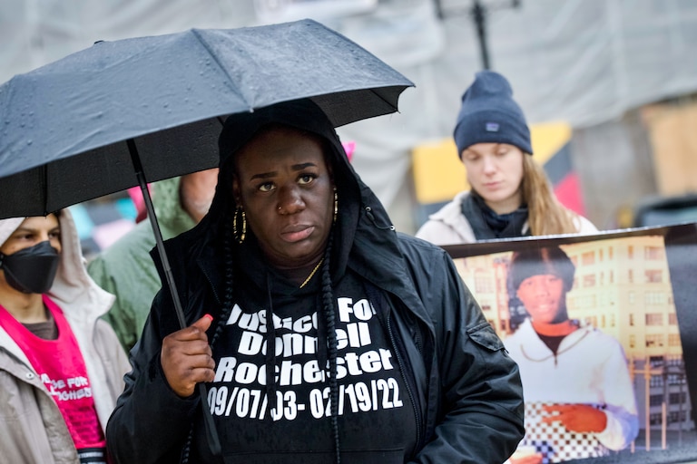 Danielle Brown, mother of Donnell Rochester, stands in the rain at an anniversary memorial vigil for her son, who was killed by police on February 19, 2022.