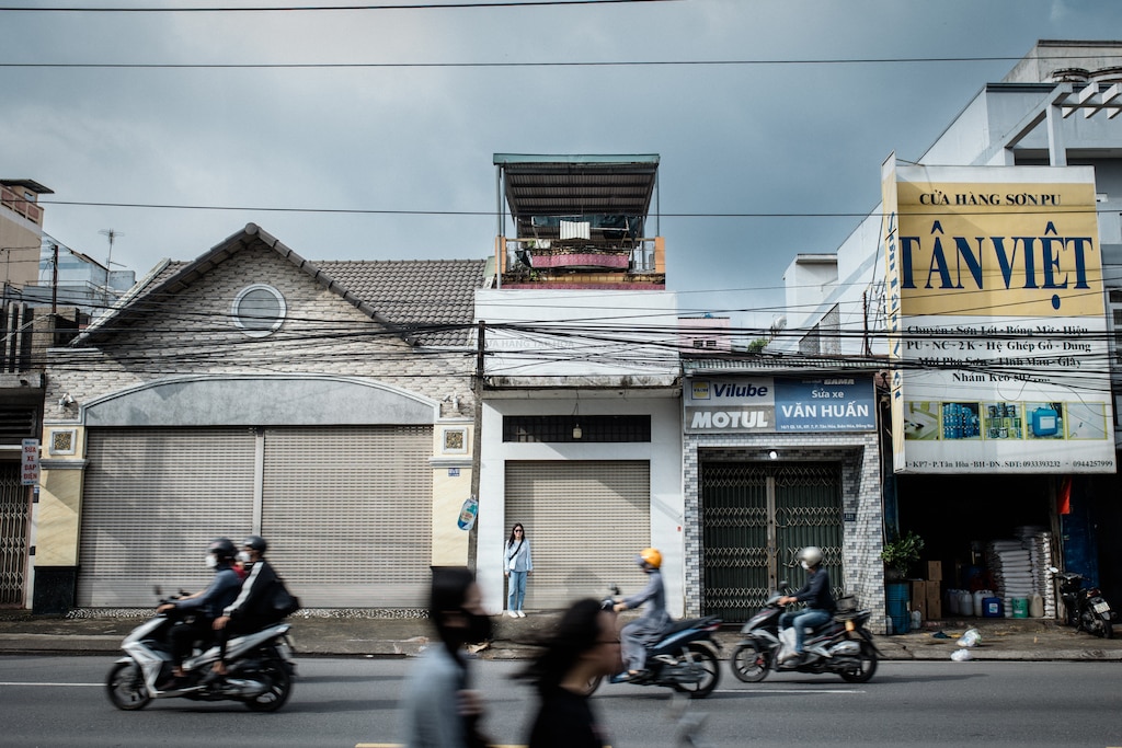 Dong Nai, Vietnam - July 26, 2026: Melissa Tran, 44, stands outside where her old home used to be in Dong Nai, Vietnam on July 26, 2026. She remembers a mud house in this street surrounded by farm land. Rosem Morton for The Baltimore Banner