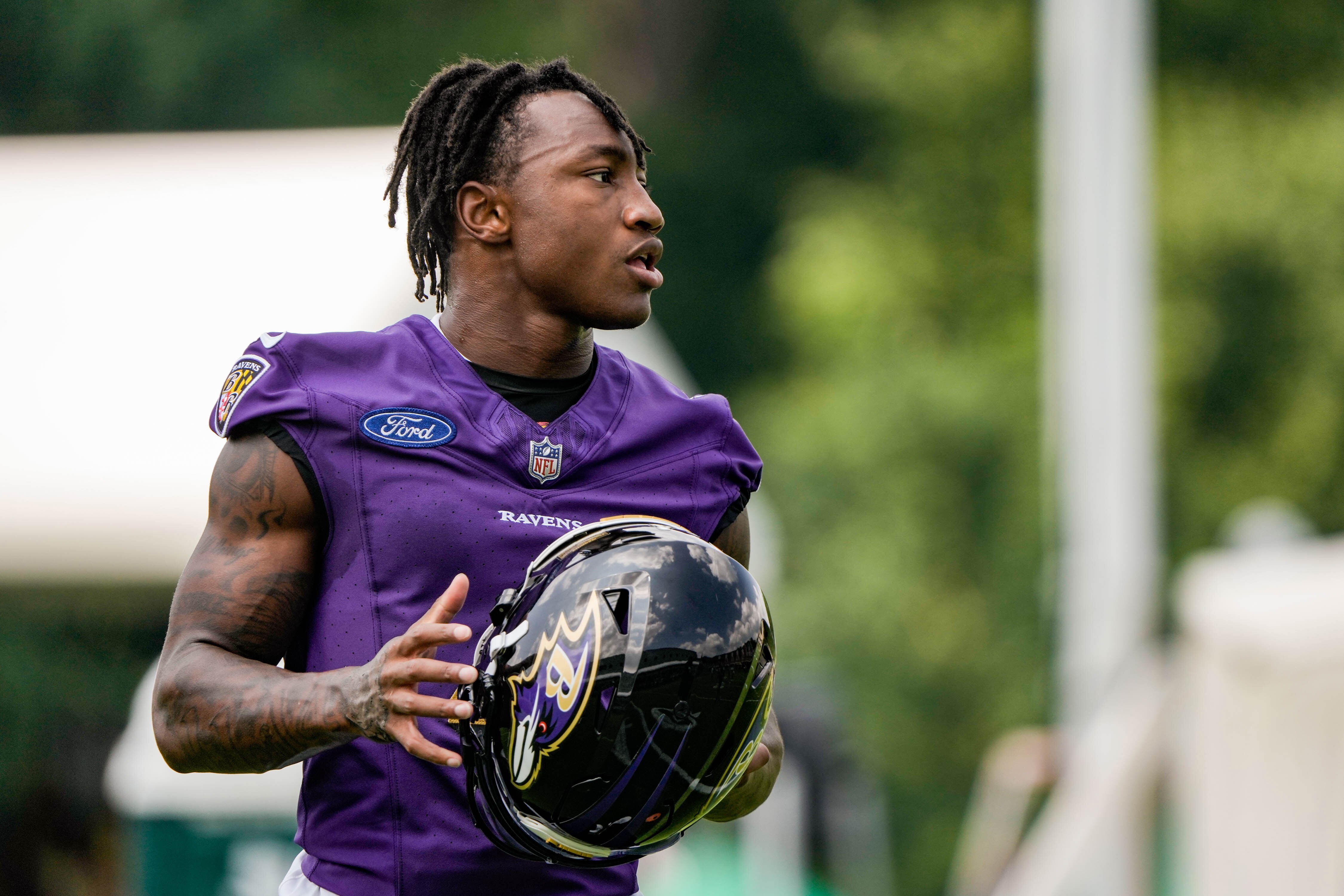 Ravens WR Zay Flowers removes his helmet at the first Ravens practice of the season on July 26, 2023.