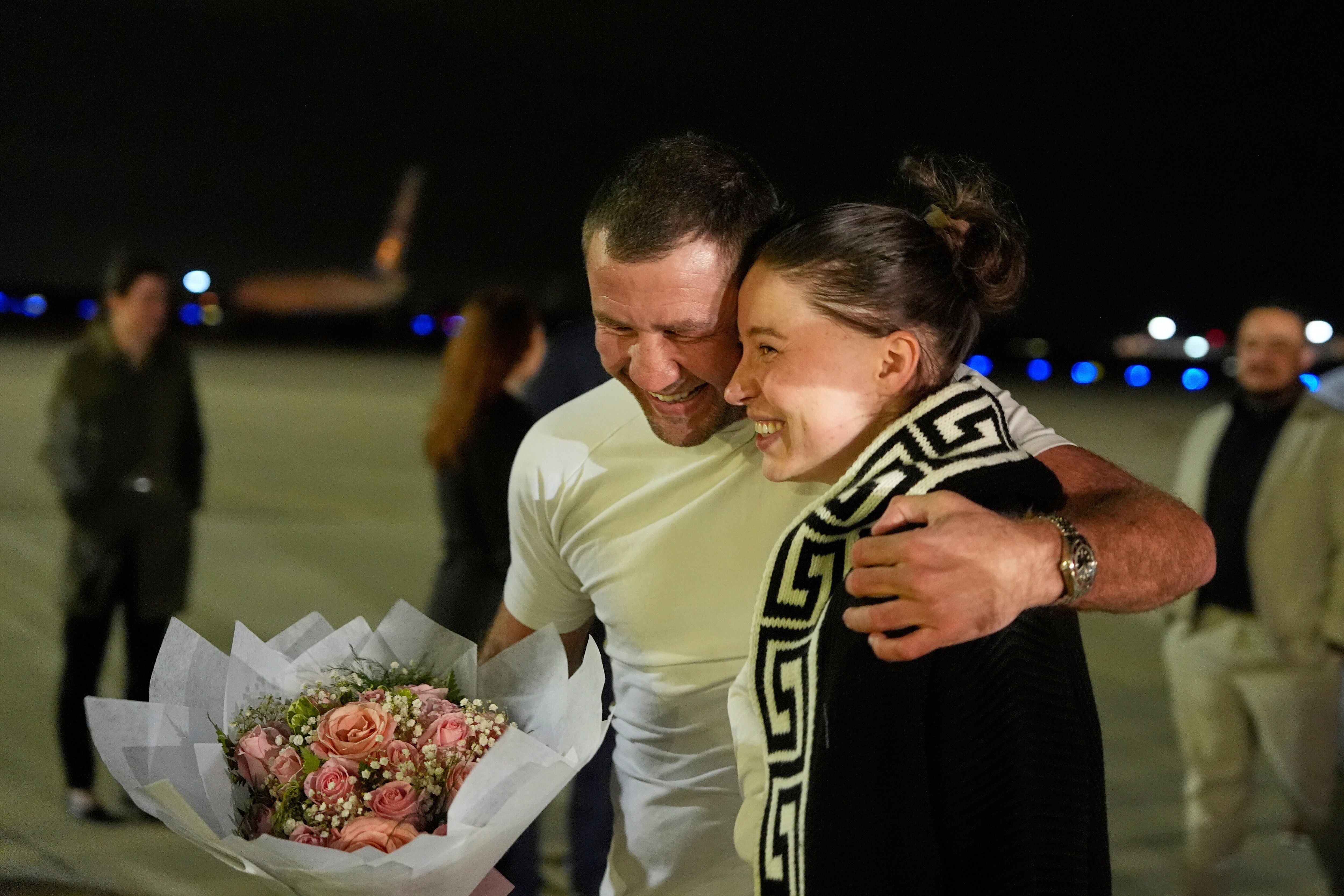 Ksenia Karelina walks with her fiancé, professional boxer Chris van Heerden, as she arrives Thursday, April 10, 2025, at Joint Base Andrews, Md. (AP Photo/Alex Brandon)