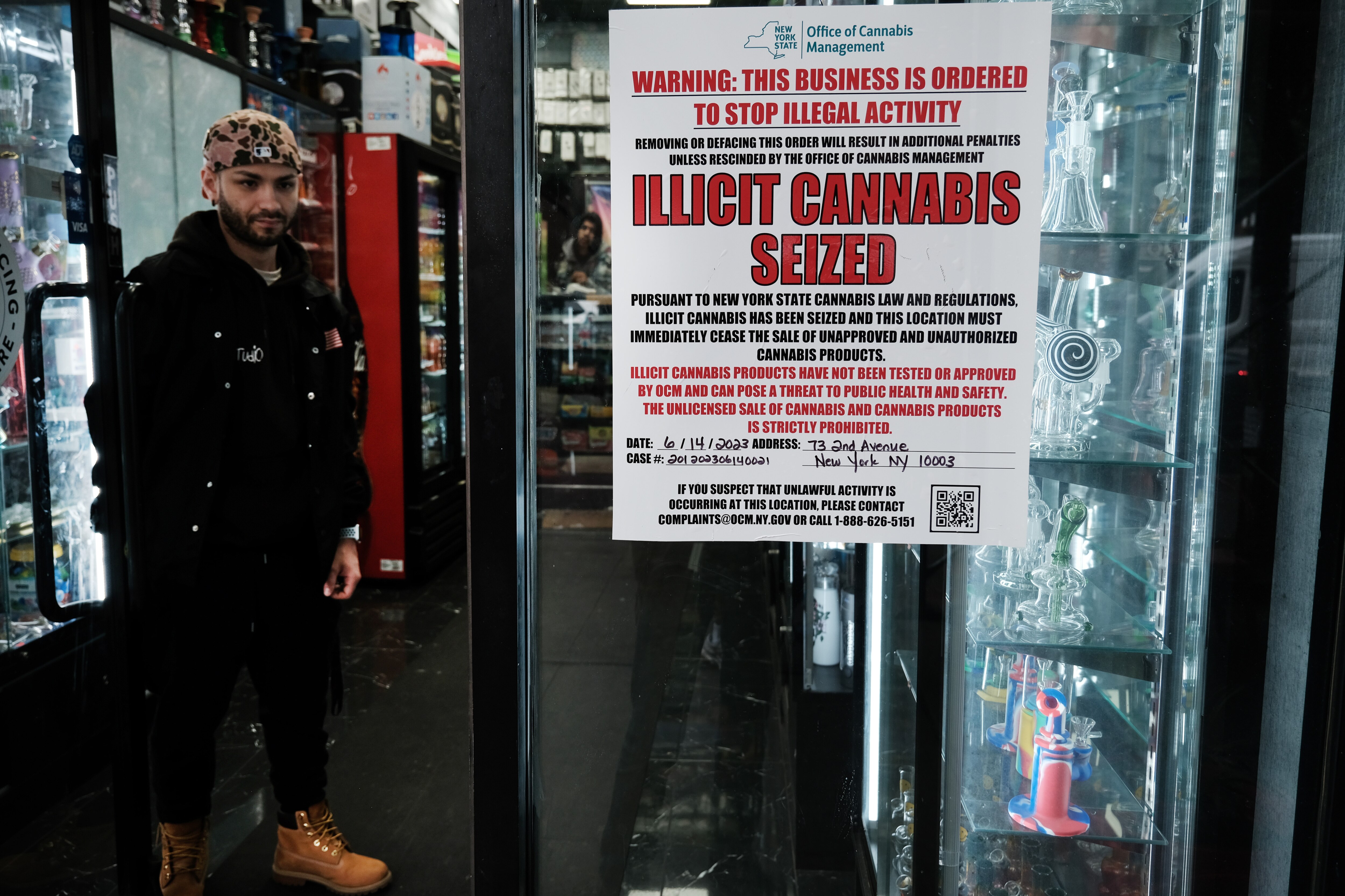 A state of New York notice posted at a business announces the seizure of “illicit” cannabis at the business as authorities crack down on unlicensed smoke shops.