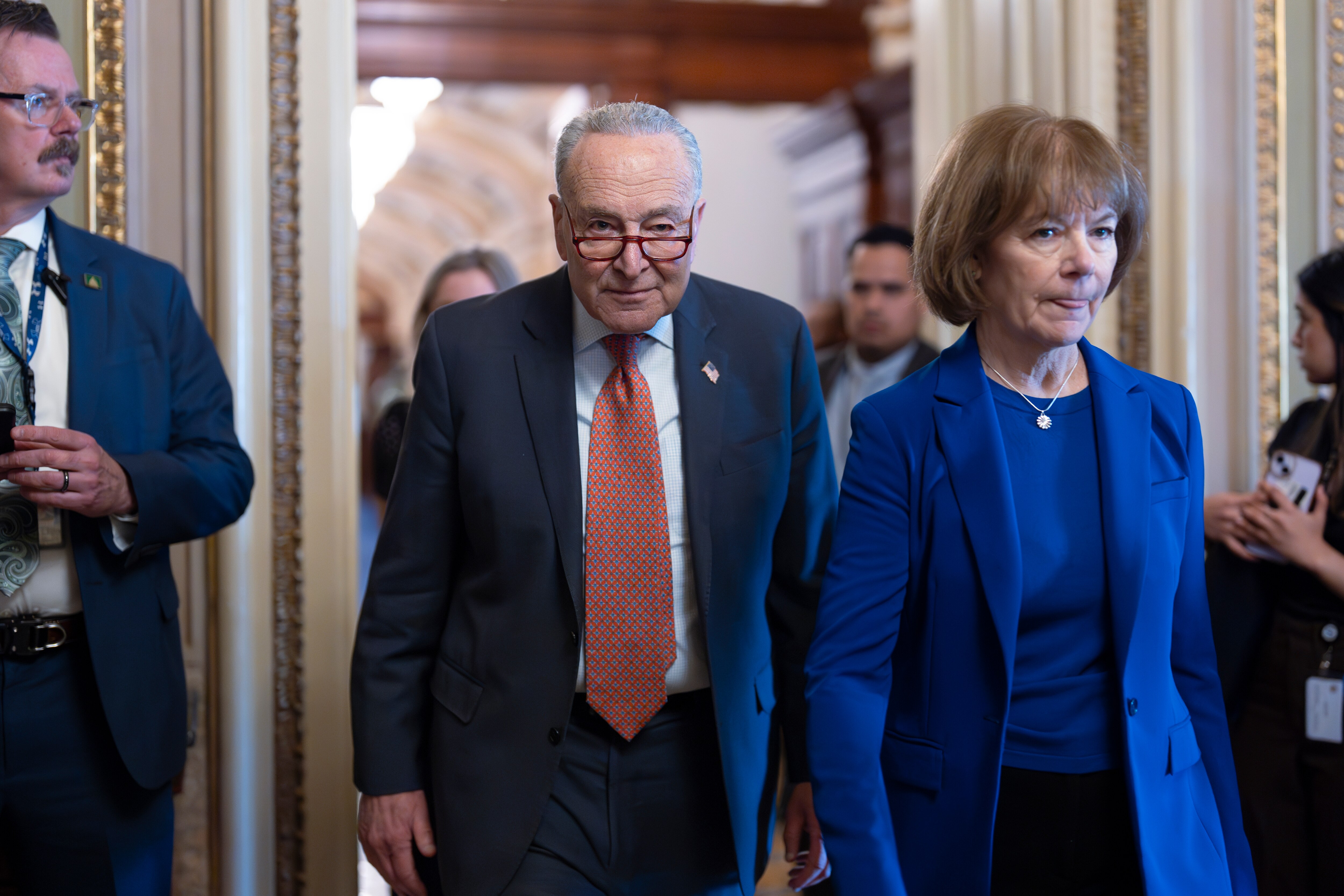 Senate Minority Leader Chuck Schumer, D-N.Y., left, walks with Sen. Tina Smith, D-Minn., as Senate Democrats gather behind closed doors to mount a last-ditch protest over a Republican-led spending bill that already passed the House, at the Capitol in Washington, Thursday, March 13, 2025.