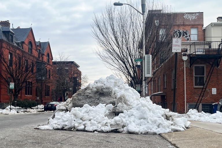 A large pile of snow partially blocks Eager Street near downtown Baltimore on Friday.