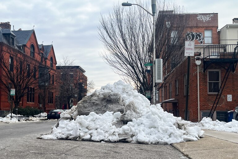 A large pile of snow partially blocks Eager Street near downtown Baltimore on Friday.
