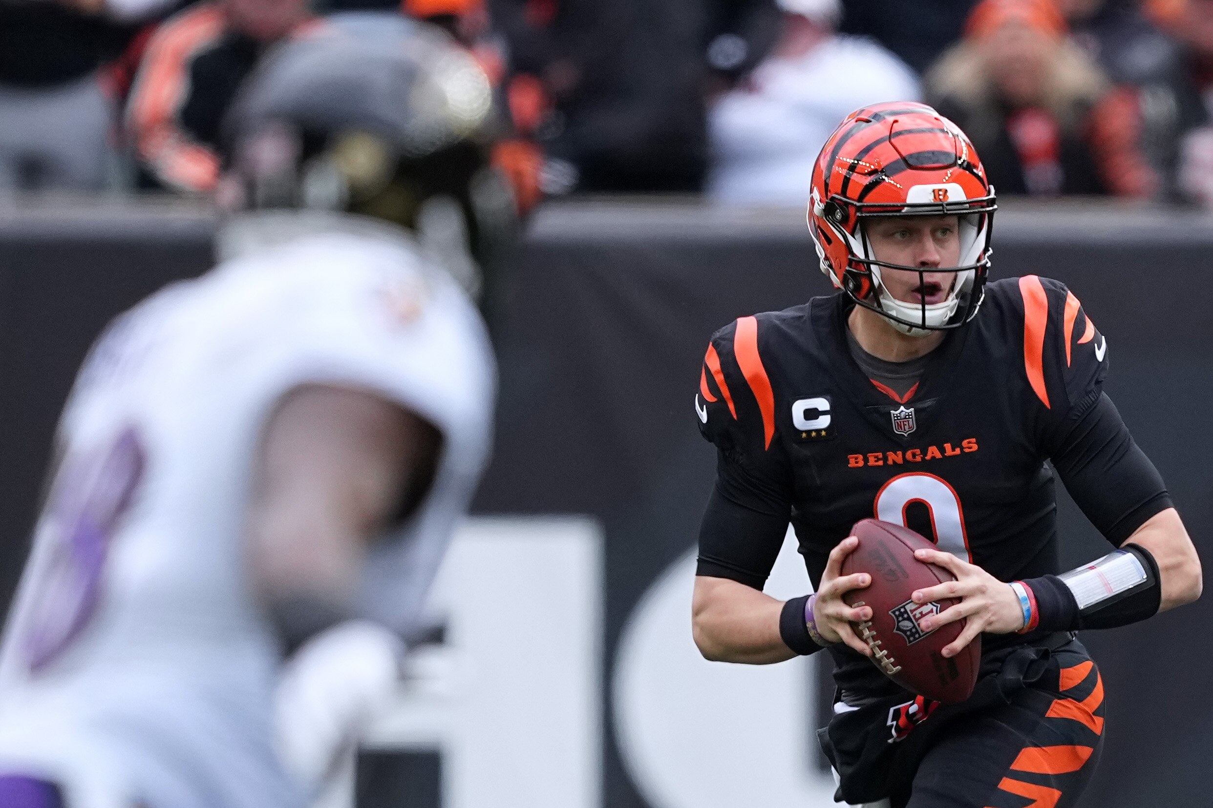 CINCINNATI, OHIO - JANUARY 08: Joe Burrow #9 of the Cincinnati Bengals scrambles during the first quarter against the Baltimore Ravens at Paycor Stadium on January 08, 2023 in Cincinnati, Ohio.