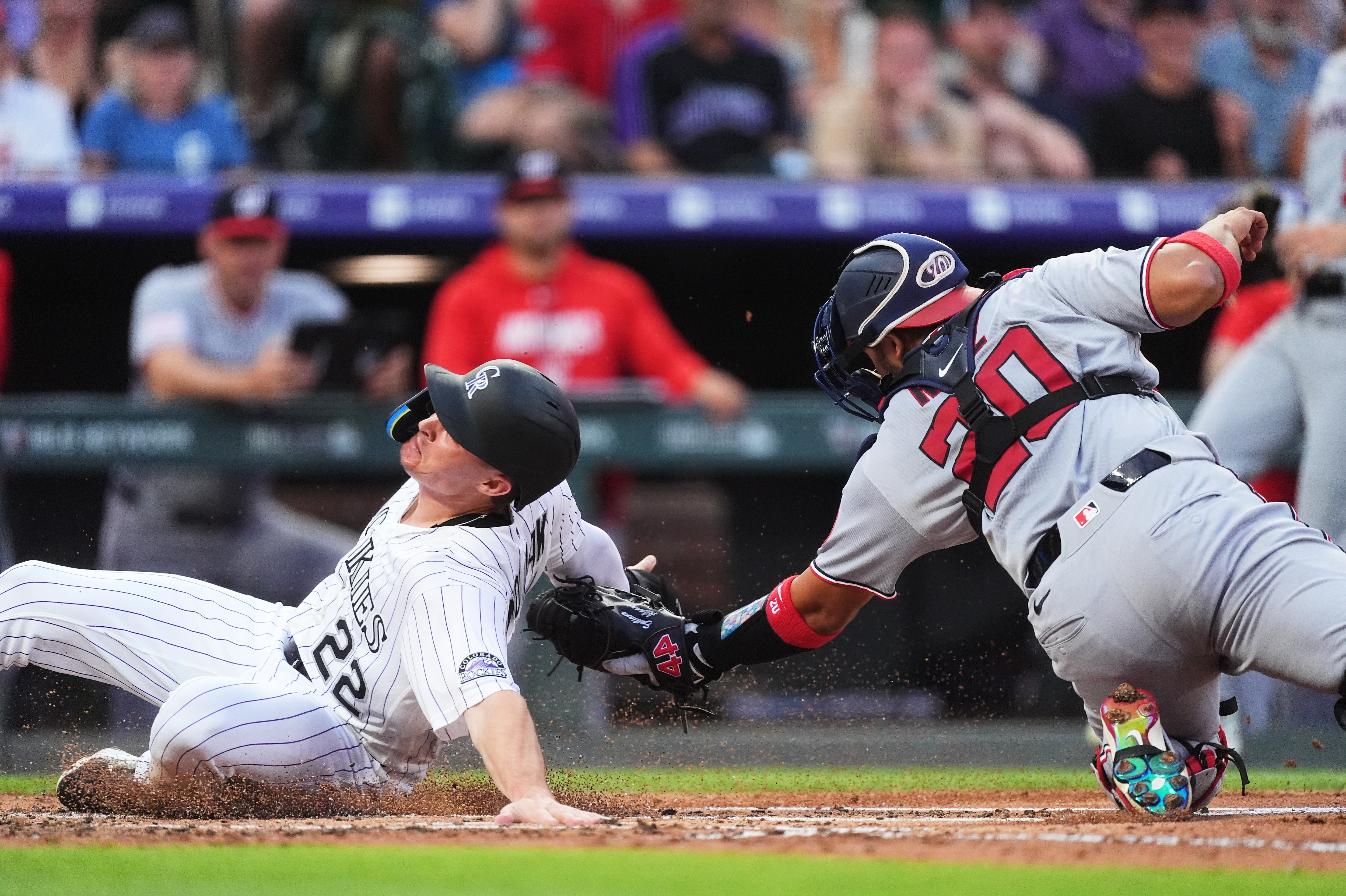 Washington Nationals catcher Keibert Ruiz, right, applies a late tag as Colorado Rockies' Mickey Moniak scores on a double hit by Jake McCarthy in the second inning.