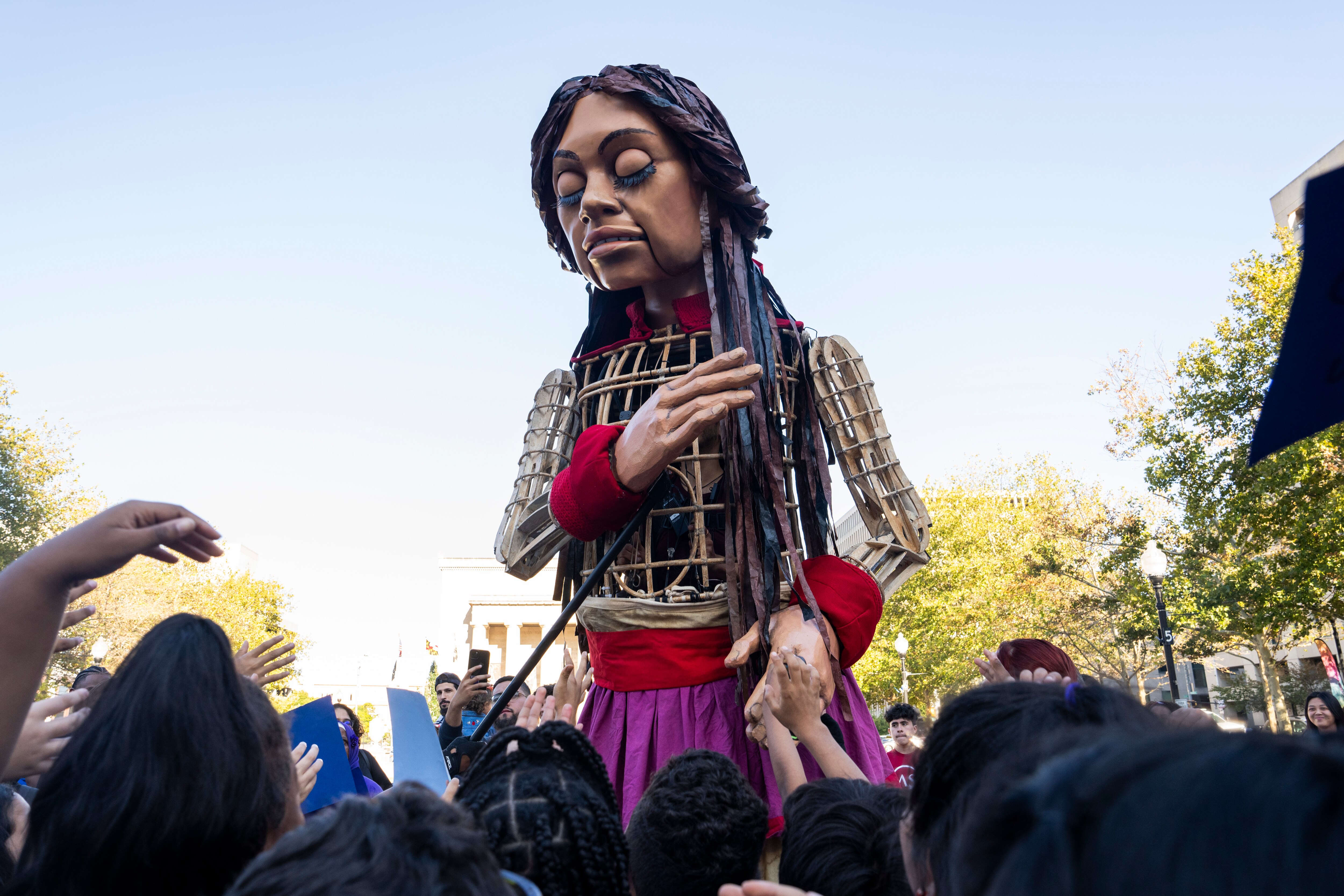 Little Amal, a twelve-foot puppet of a 10-year-old Syrian refugee girl, visits City Hall to meet Mayor Brandon Scott and the children of Baltimore on September 15, 2023. 