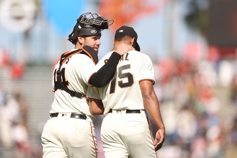 Austin Wynns congratulates reliever Camilo Doval after the San Francisco Giants beat the Atlanta Braves on Sept. 14, 2022.