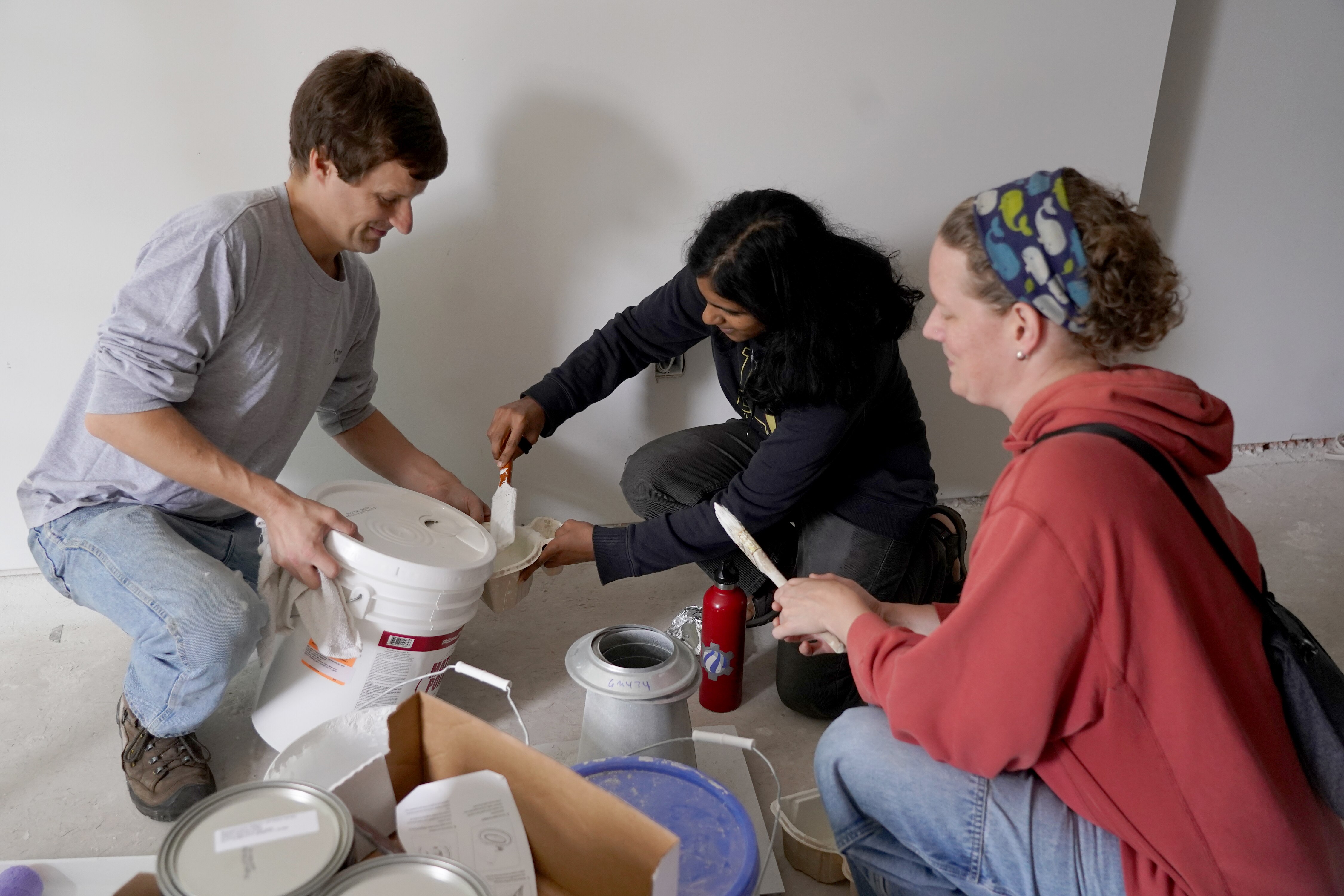 Breath of God Lutheran Church in Highlandtown renovated a vacant house that is to become a home for a new refugee family. Volunteers painted the house Friday and Saturday in hopes of having the home ready for occupancy by February 2023. (L to r) Pastor Mark Parker prepares the paint for volunteers Anisha Jayodevan and Michelle Bennett.